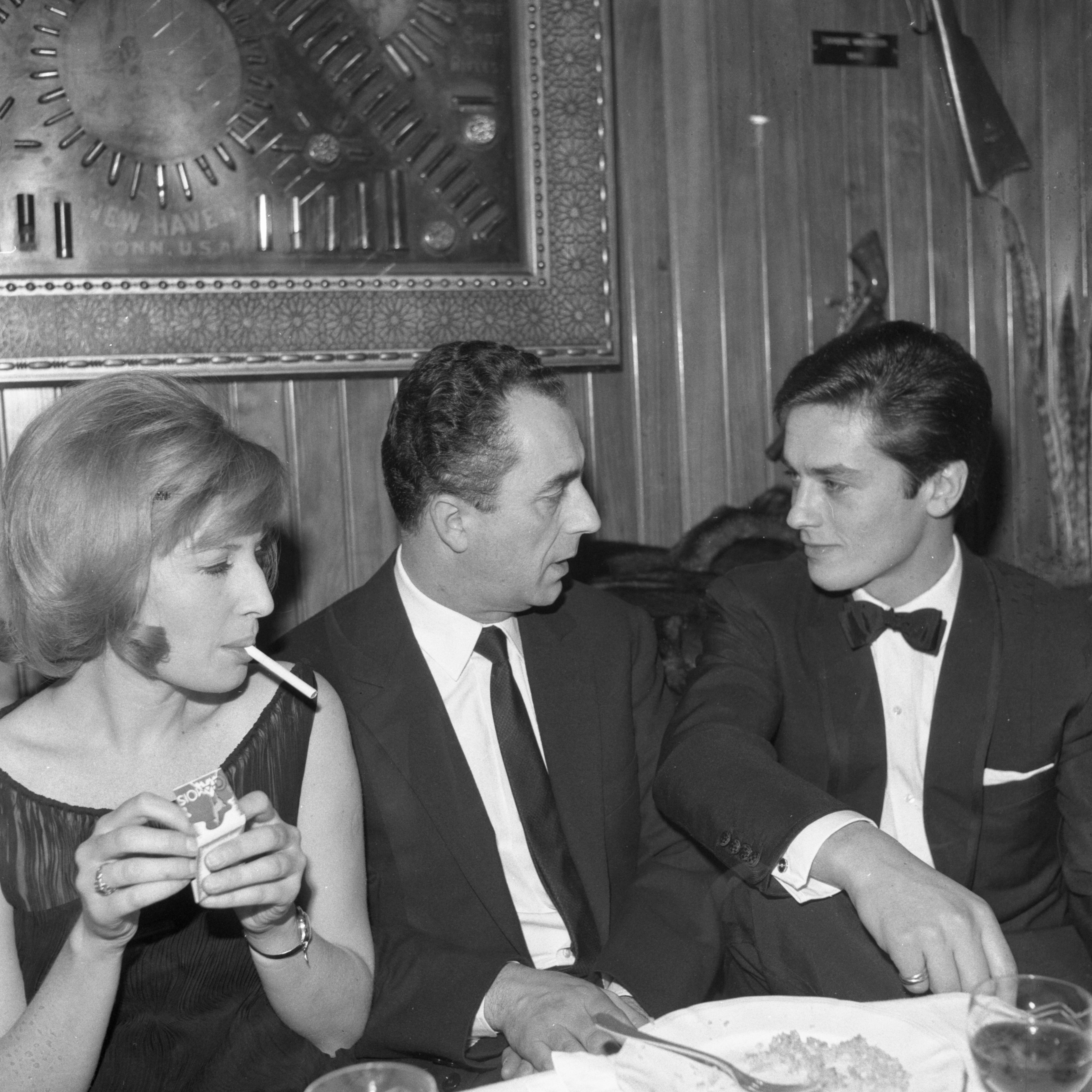 Antonioni tra Monica Vitti e Alain Delon al ristorante dopo la prima del film "La notte" nel 1961