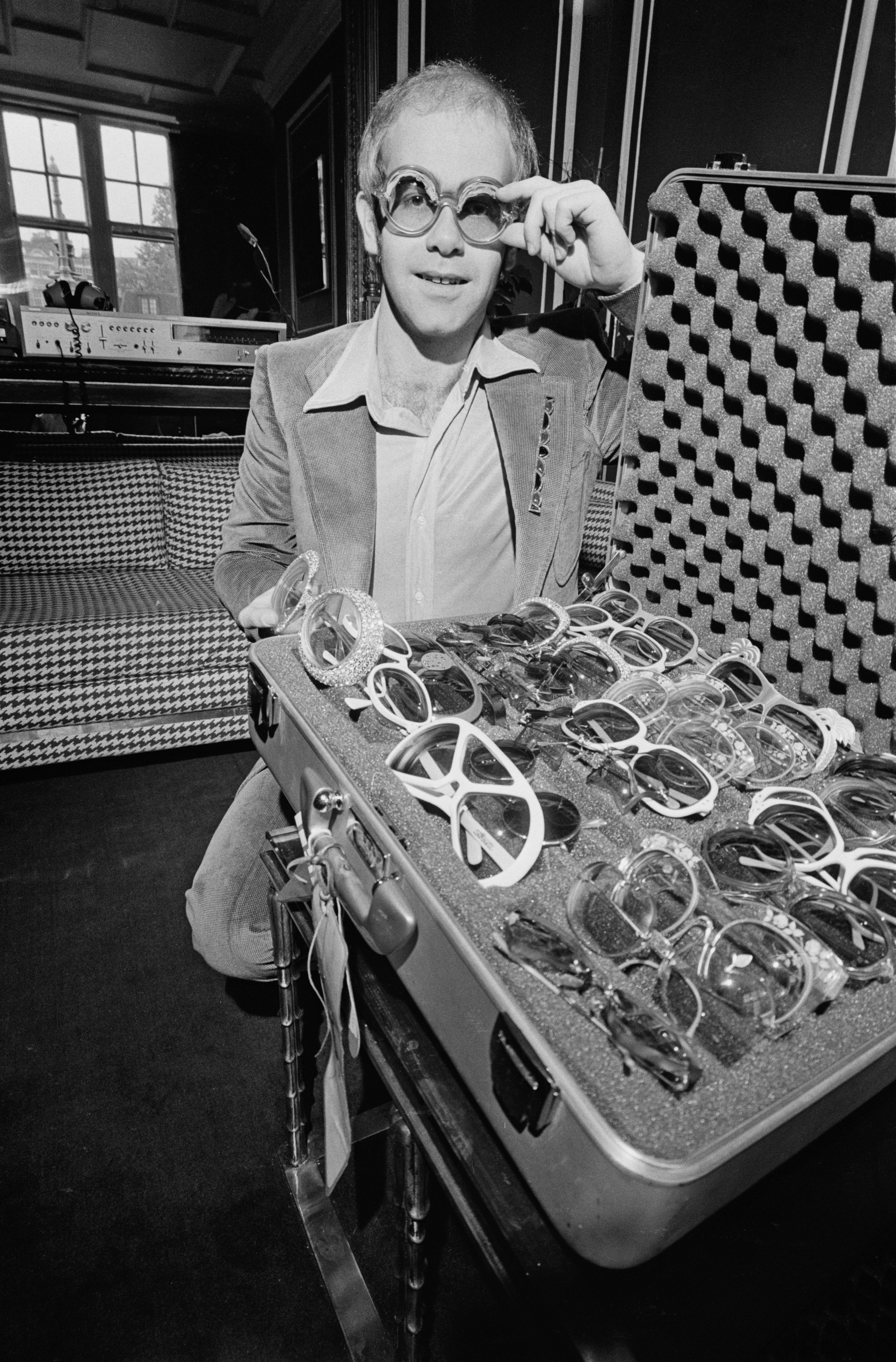 Elton John e la sua valigia da viaggio contenente una selezione dei suoi celebri e spettacolari occhiali nel settembre del 1974 