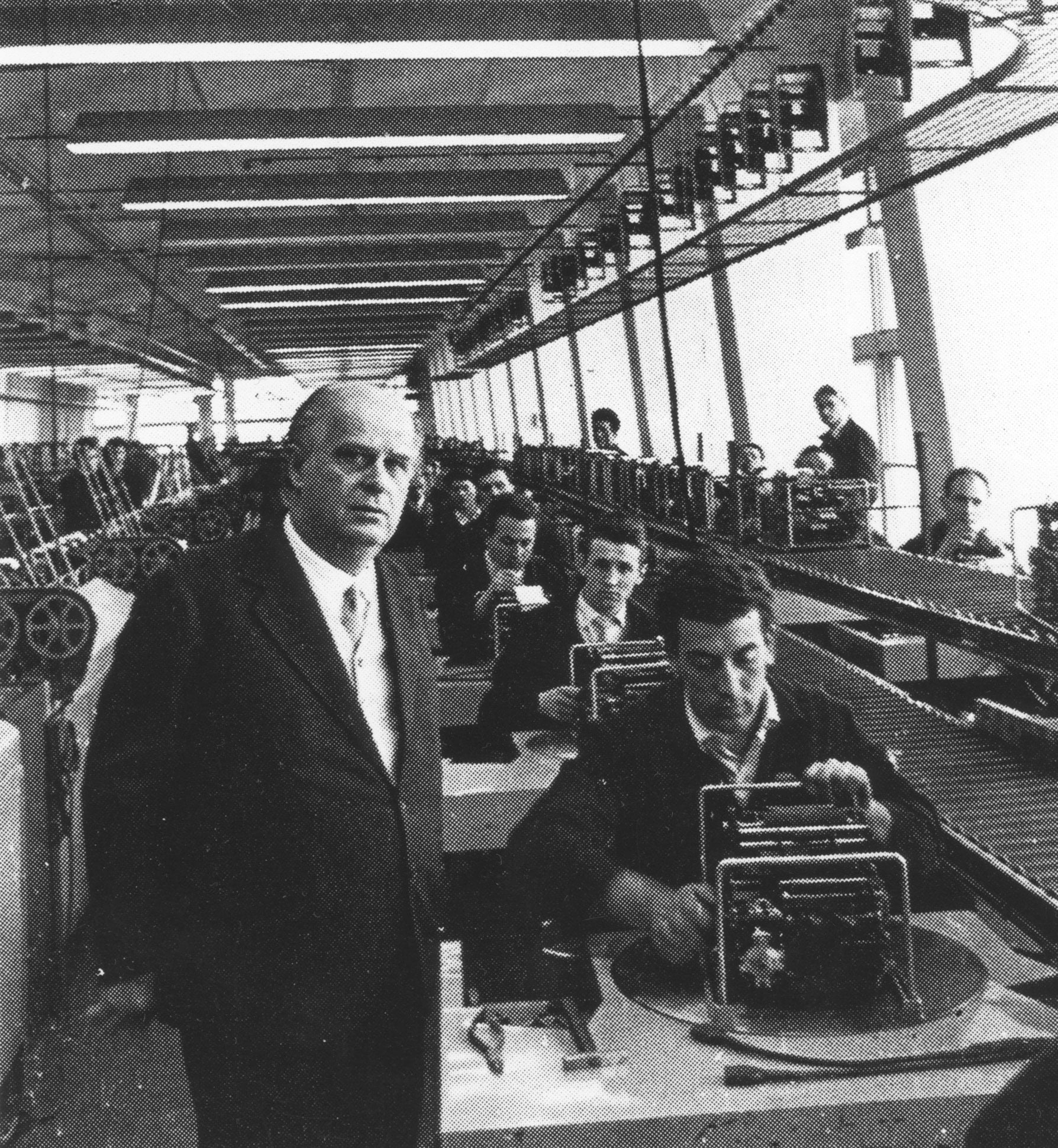 Adriano Olivetti ritratto in fabbrica con i suoi operai, nel 1950 circa
