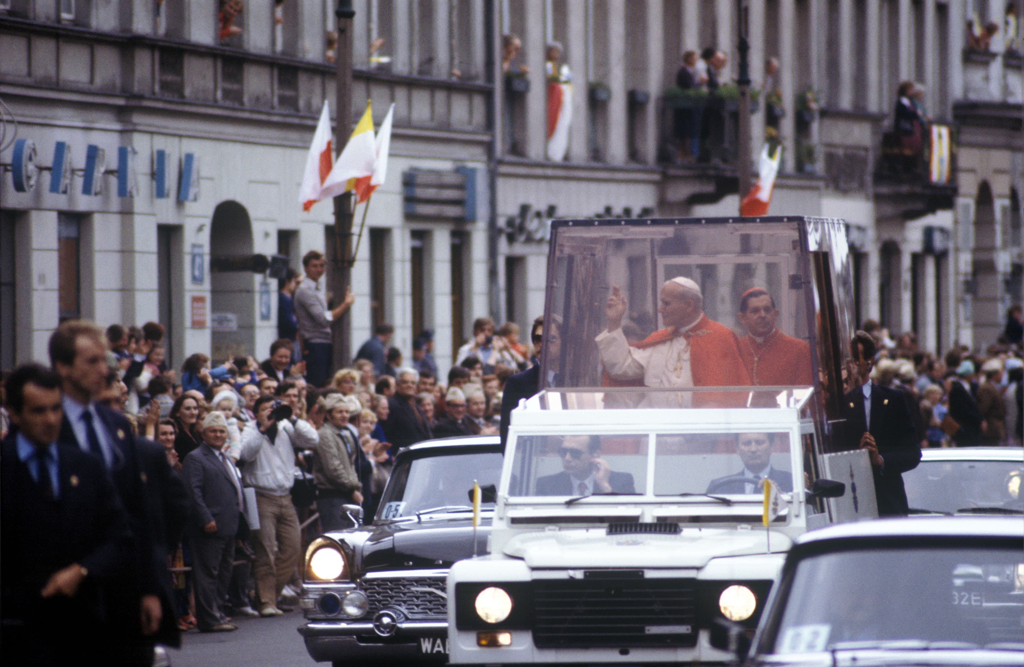Il Papa durante una visita in Polonia, nel 1983. Dopo l'attentato del 1981 la macchina su cui viaggia viene rinforzata con una cabina di protezione