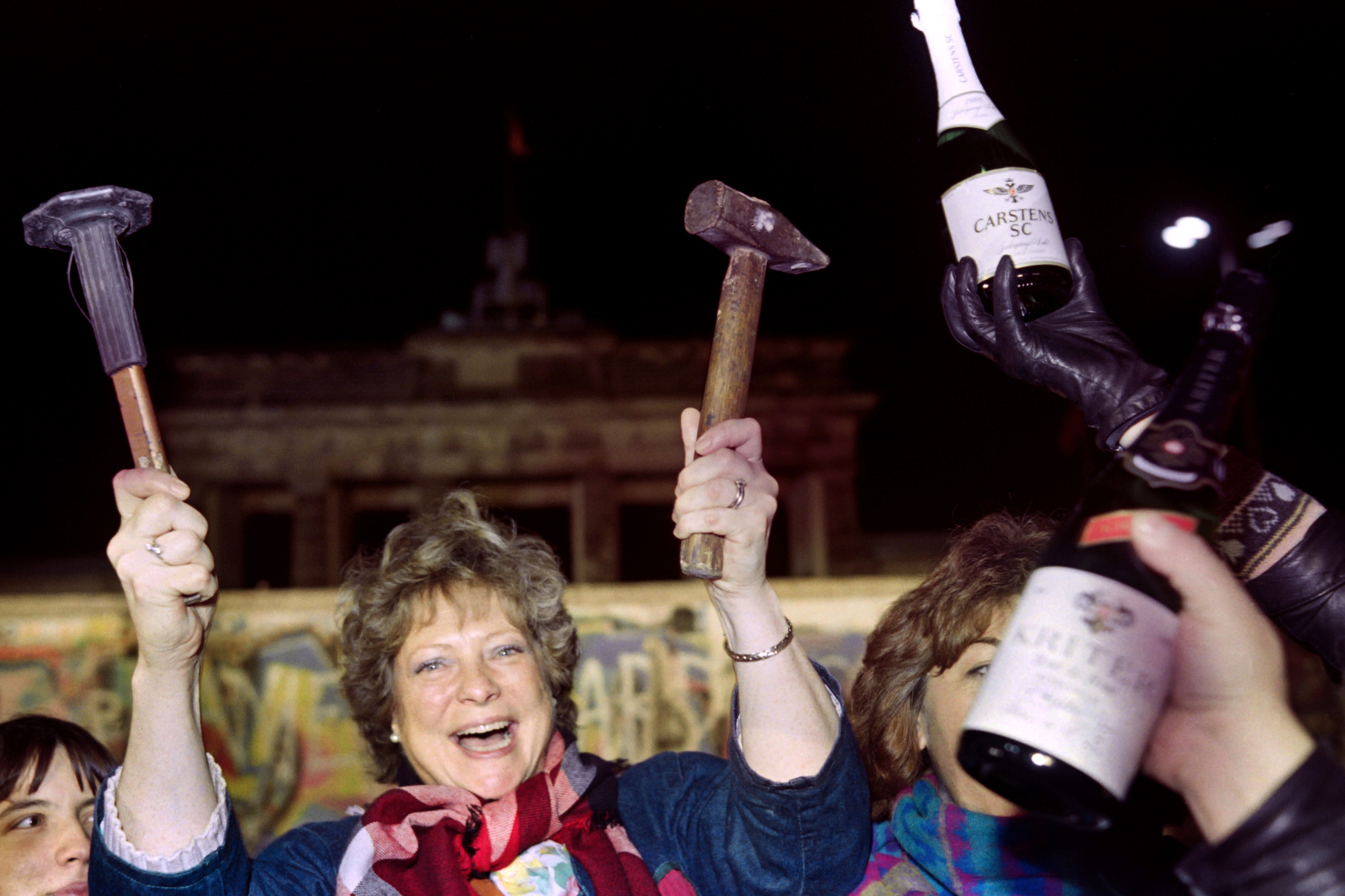 Migliaia di persone in strada con picconi e martelli cominciano a rompere il muro, festeggiando l’ormai imminente riunificazione