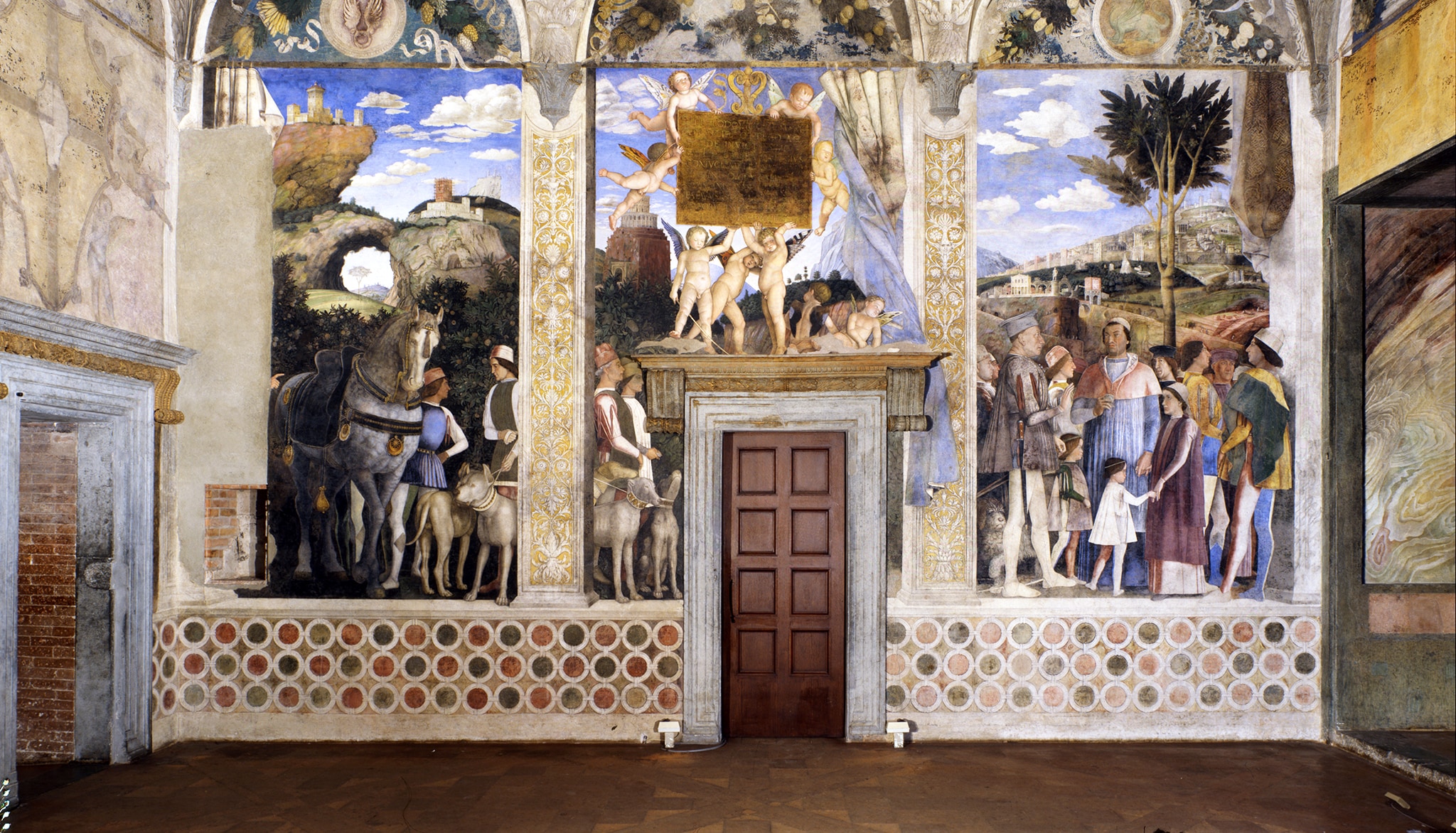 L'incontro; Camera degli Sposi, Andrea Mantegna (1465-1474). La Camera Picta, situata nella massiccia torre nord-est del Castello, è un piccolo vano quadrato illuminato da sole due finestre, che Mantegna trasformò in uno spazio aperto e luminoso grazie a un progetto decorativo unitario concepito in chiave prospettica. Il ciclo celebra l'ascesa politico-dinastica della famiglia Gonzaga in occasione dell'elezione di Francesco a cardinale.