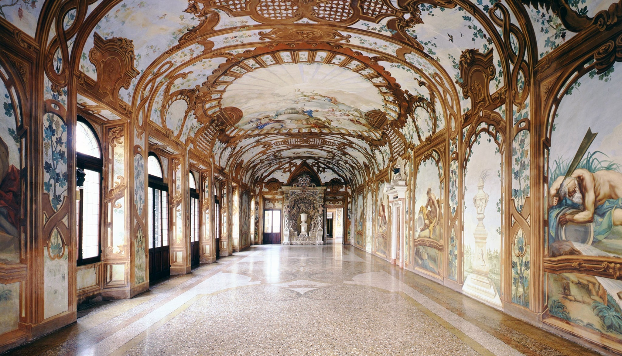 Galleria dei Fiumi. L'ambiente, progettato nel 1579 da Pompeo Pedemonte in un'ala di Corte Vecchia, per il nuovo appartamento di Guglielmo Gonzaga, era una loggia chiusa affacciata su un giardino pensile. L'attuale decorazione settecentesca della Galleria, fu realizzata per il nuovo assetto di residenza ufficiale del governo austriaco.