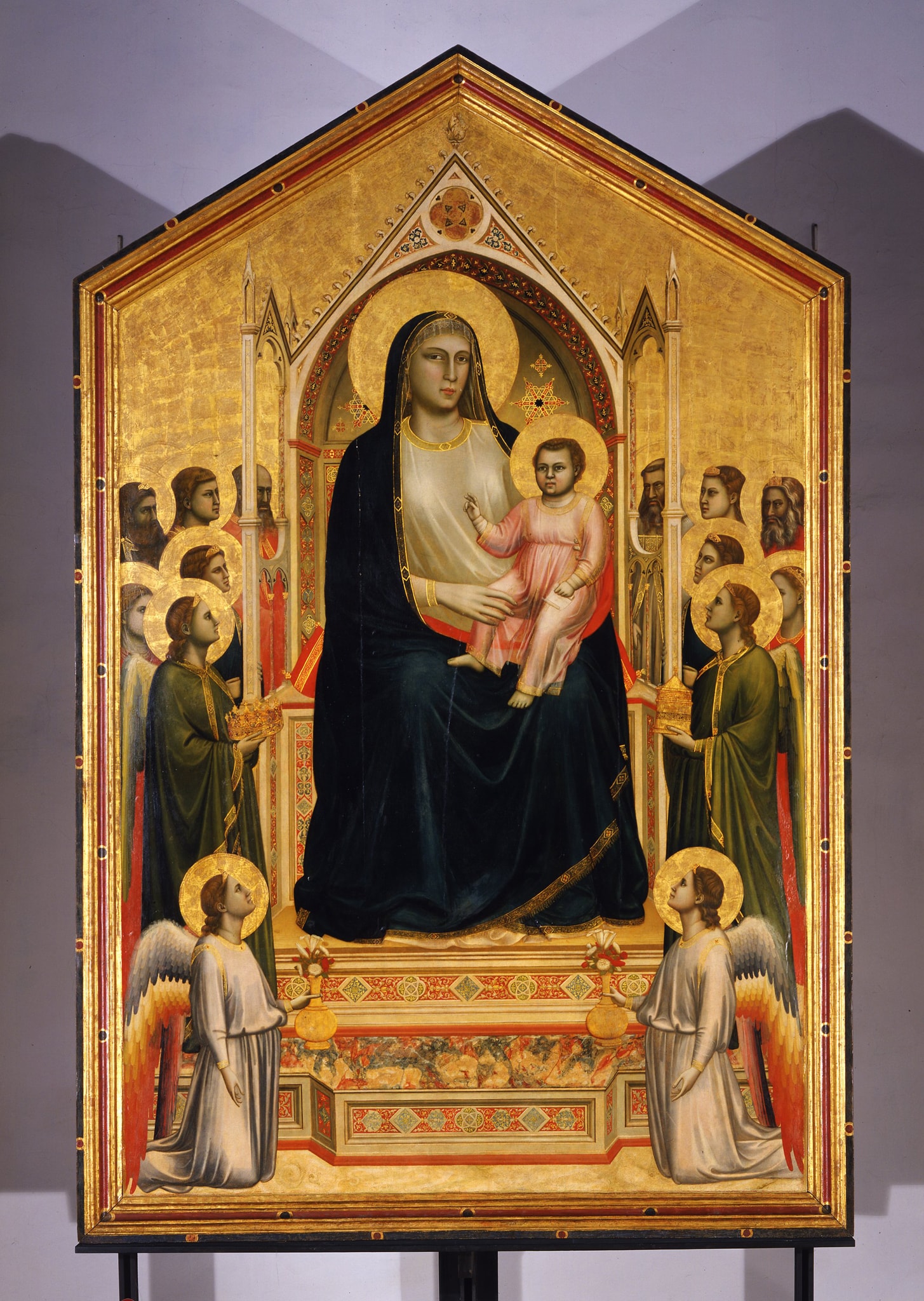 Giotto, Madonna con Bambino e Santi, 1300-1305 ca., tempera su tavola, fondo oro, 325x204cm. L'opera proviene dalla chiesa fiorentina di Ognissanti (XIII sec.) e fu eseguita quando Giotto era già artista di grande fama. Questa Maestà, iconografia molto diffusa all'epoca, rappresentò un modello di ispirazione per molti pittori.