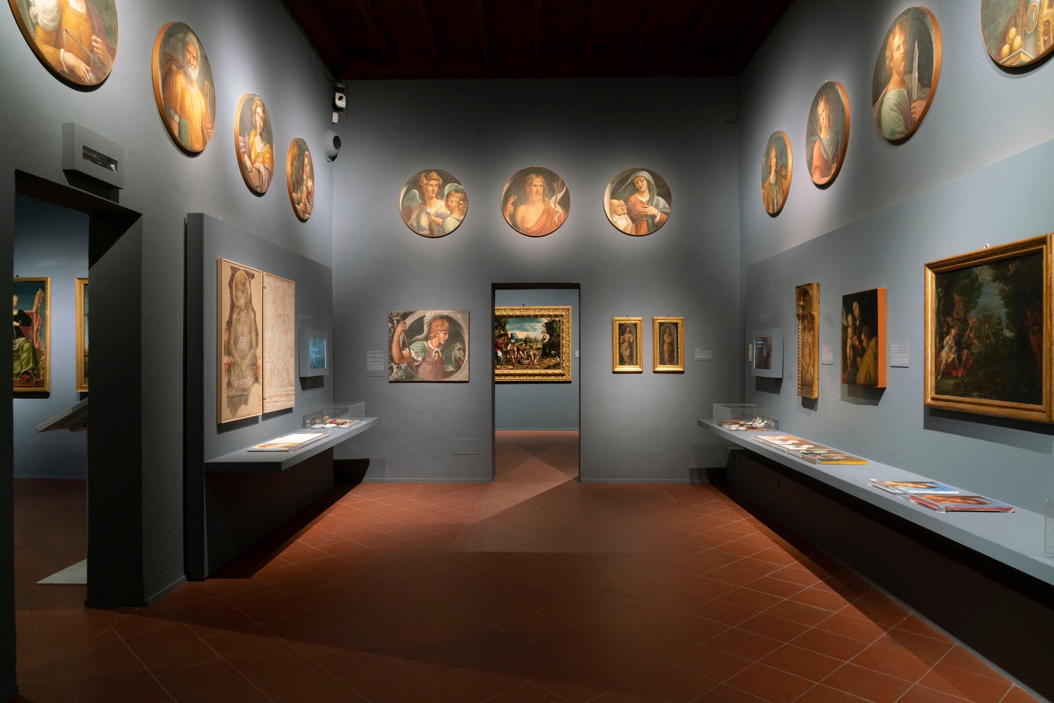 Sala 5. Il San Giorgio sulla parete di fondo a sinistra e la serie dei tondi esposta nella parte superiore della sala, sono affreschi staccati in origine parte del fregio dipinto da Garofalo, Girolamo da Carpi e collaboratori nel refettorio del convento di San Giorgio a Ferrara (1530-50 ca.); di proprietà della Fondazione Estense, già Cassa di Risparmio, sono esposti in Pinacoteca dal 1985.