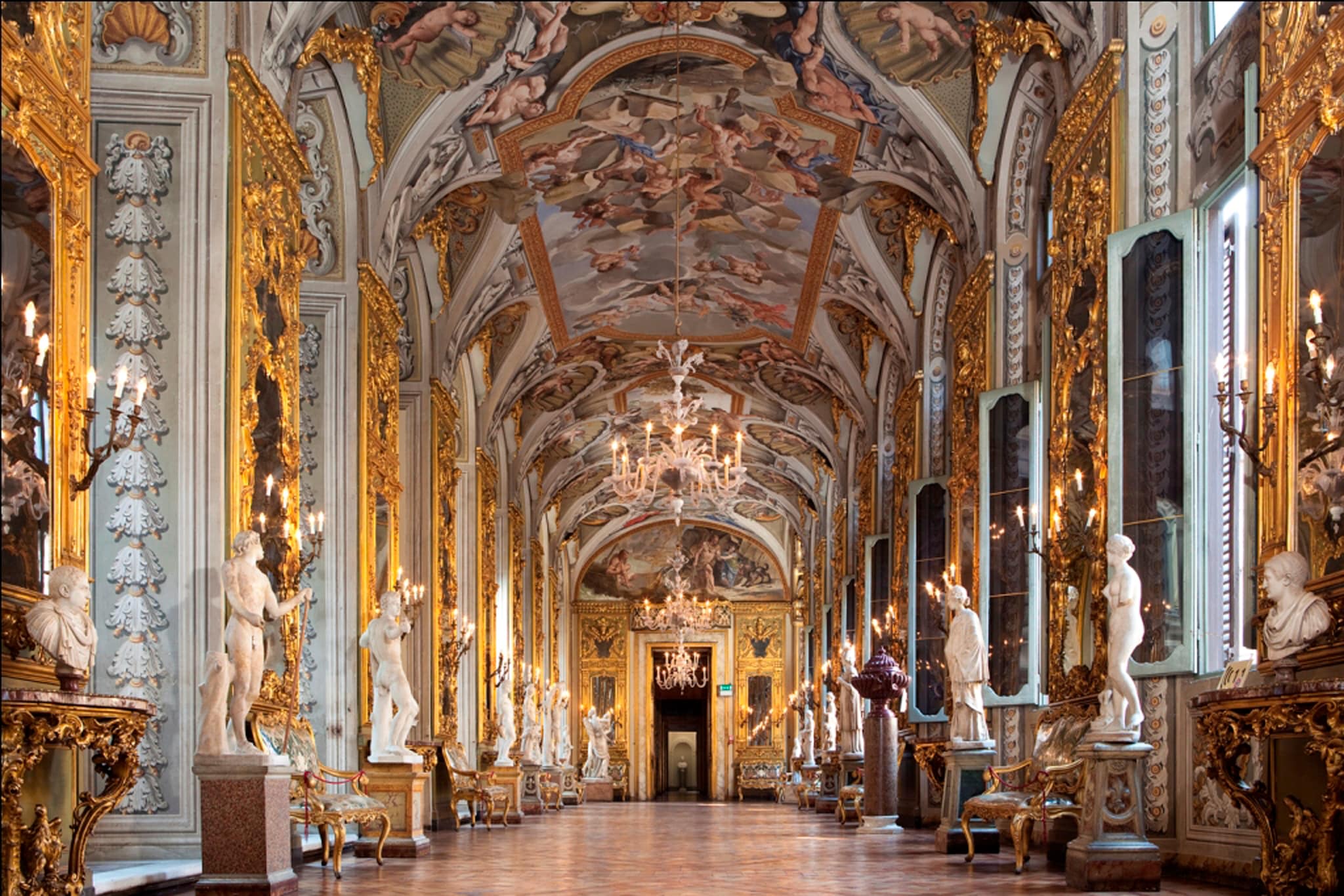 La Galleria degli Specchi. Il lungo salone, il secondo dei quattro bracci della Galleria, affacciati sul cortile interno, presenta nel soffitto, le "Storie di Ercole" del bolognese Aureliano Milani (1731-34) e alle pareti, grandi preziosissimi specchi, fatti venire nel primo '700 da Venezia . Le statue sono di epoca antica. 