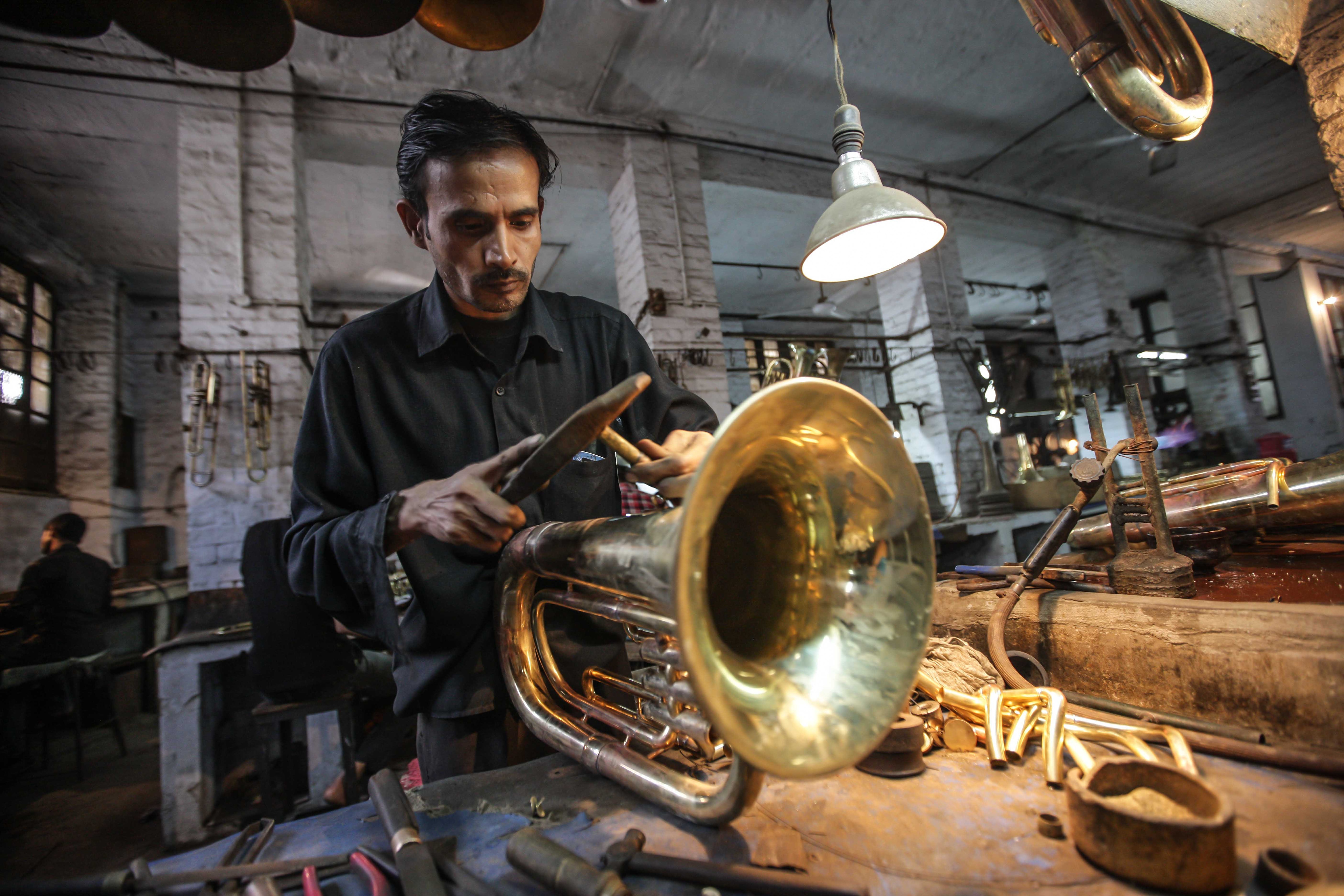2013: un artigiano lavora su un eufonio in un laboratorio di strumenti a Meerut dell'Uttar Pradesh nel Nord dell'India. Meerut, che dista circa settanta chilometri da Nuova Delhi, ospita la più grande produzione di strumenti musicali dell'India.