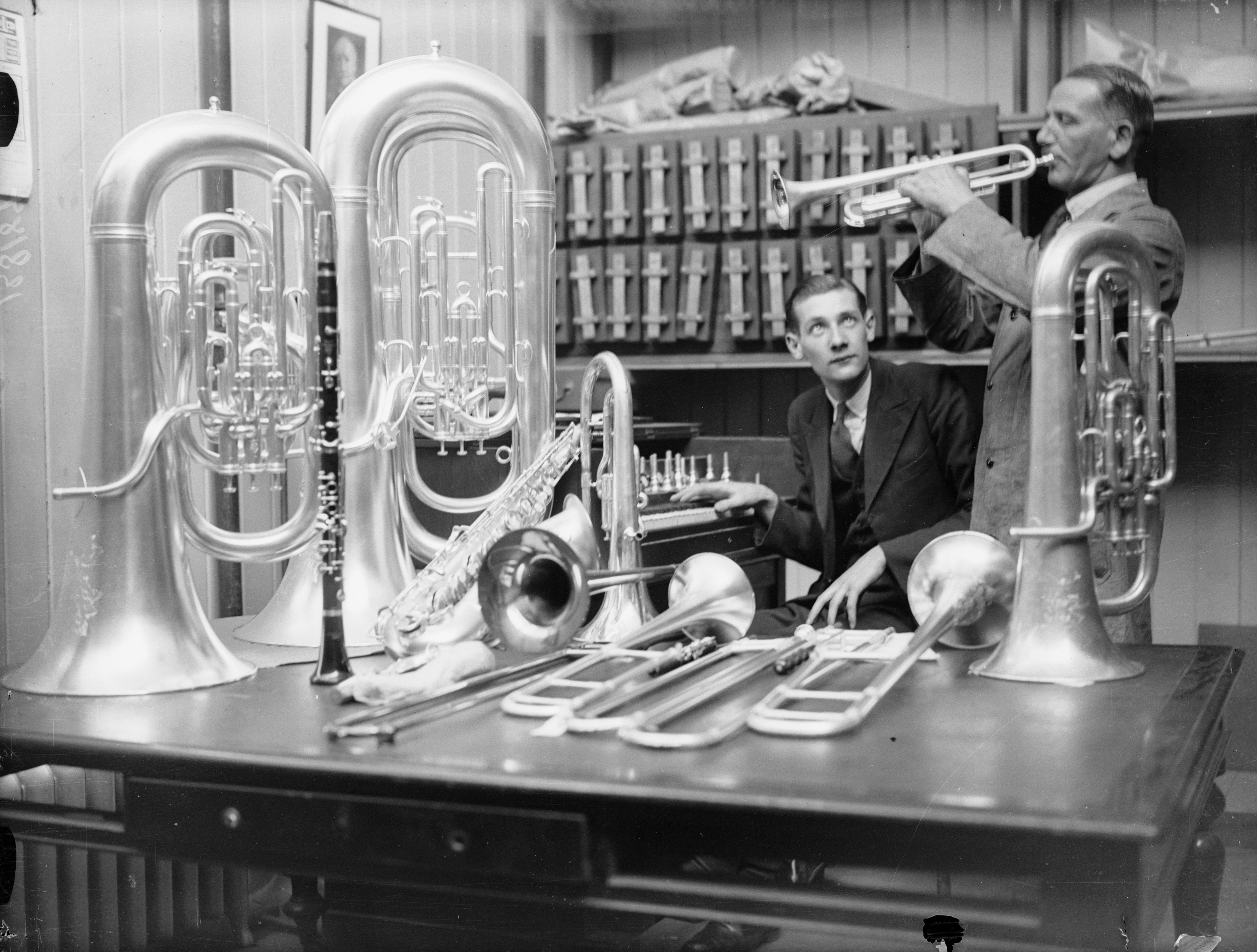 1936: un lavoratore della fabbrica di strumenti musicali di Boosey & Hawkes a Edgware, Londra, prova una cornetta.