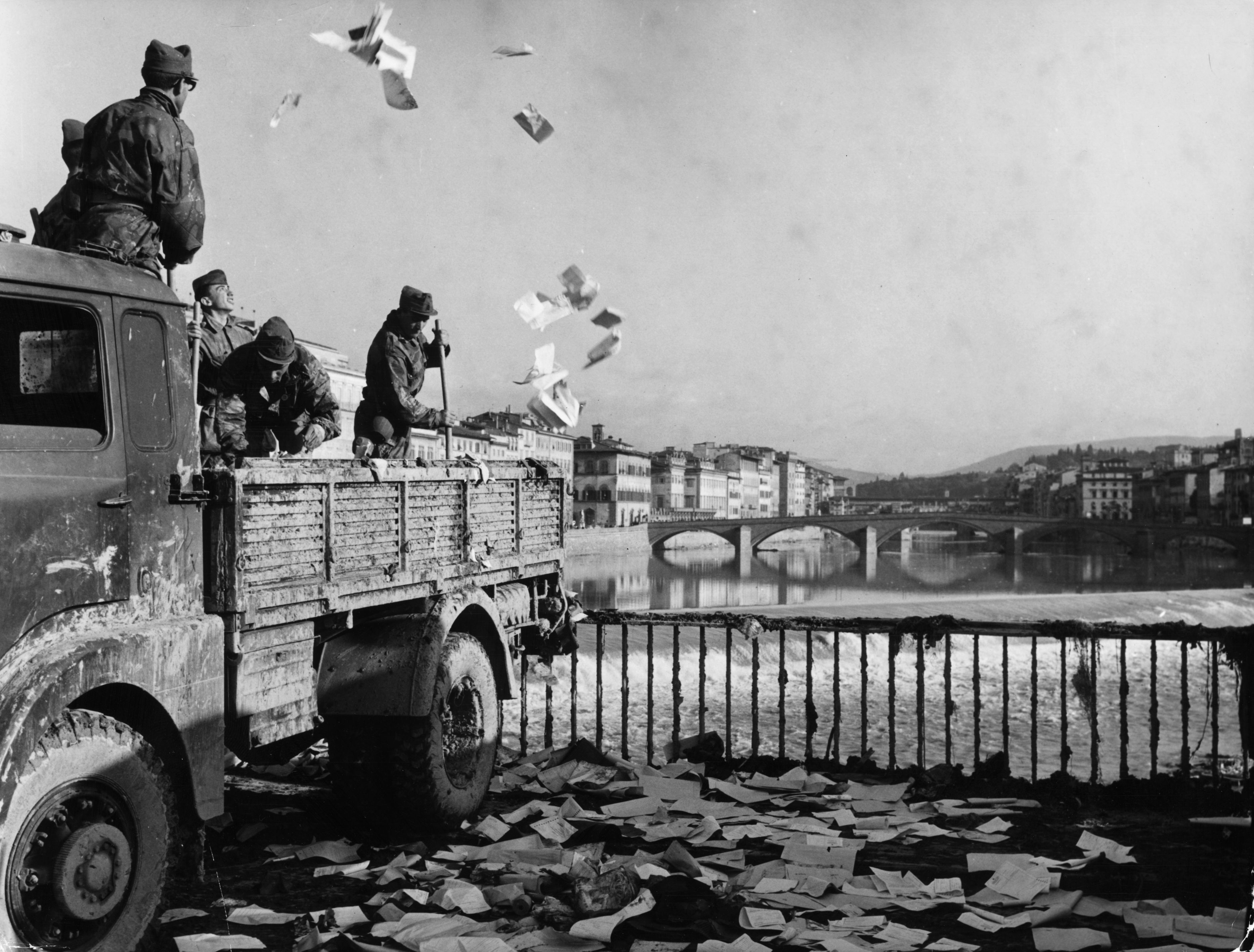 I soldati italiani che tentano di spazzare via i detriti lasciati dal fango