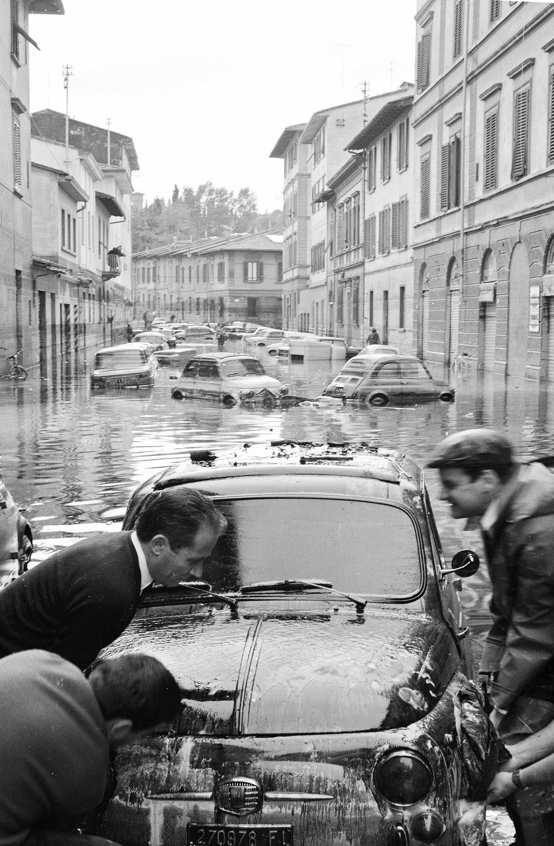 Alcune persone riescono a risollevare una macchina. Dopo la fine dell'alluvione la città è ricoperta da una distesa di acqua e melma, all'interno della quale si ritrovano oggetti d'ogni genere e carogne di ogni specie