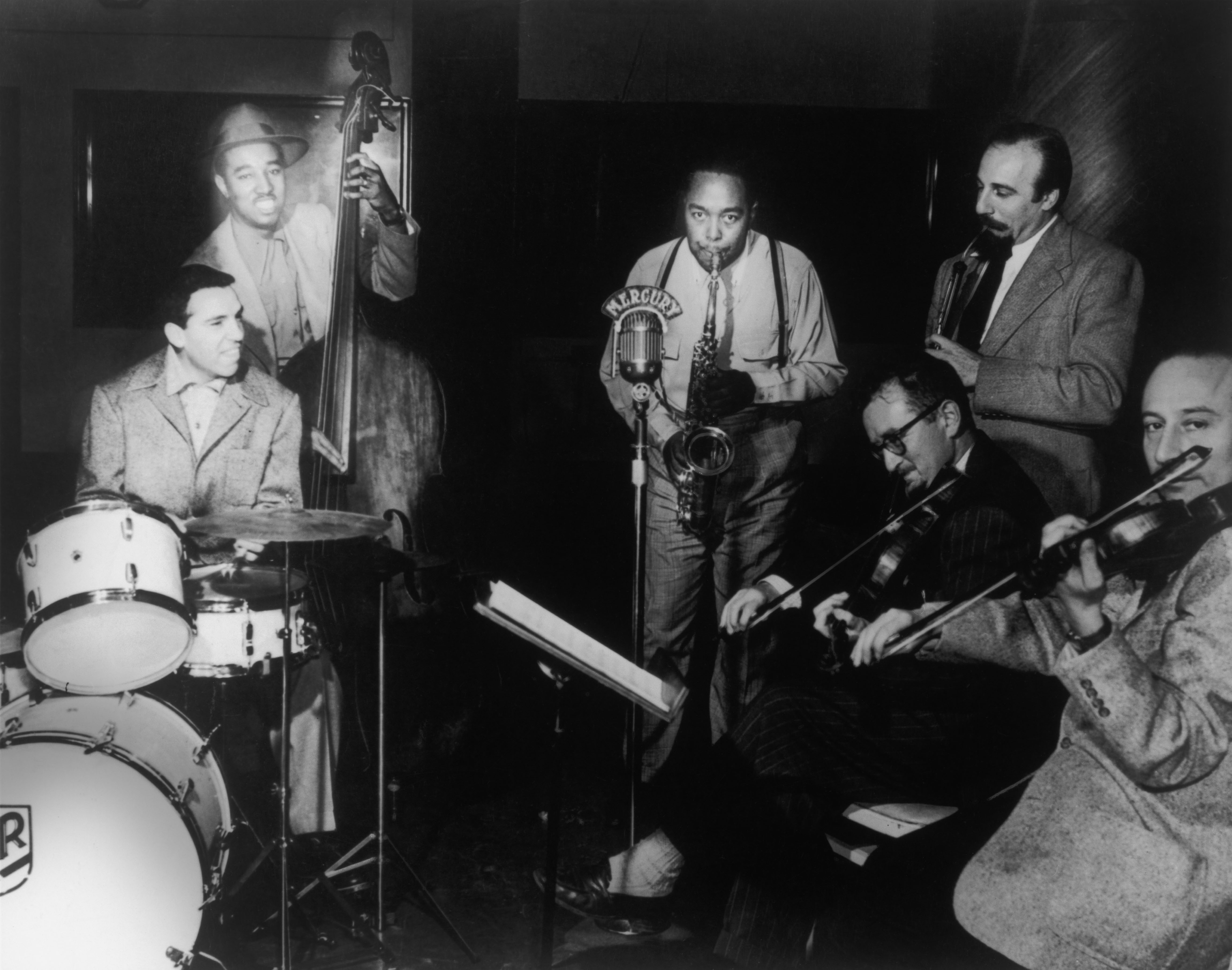 1949: Charlie Parker e l’orchestra d'archi con la quale, tra il 1947 e il 1952, incise numerosi standard americani. A sinistra, Buddy Rich (batteria) e Ray Brown (contrabbasso). New York City.