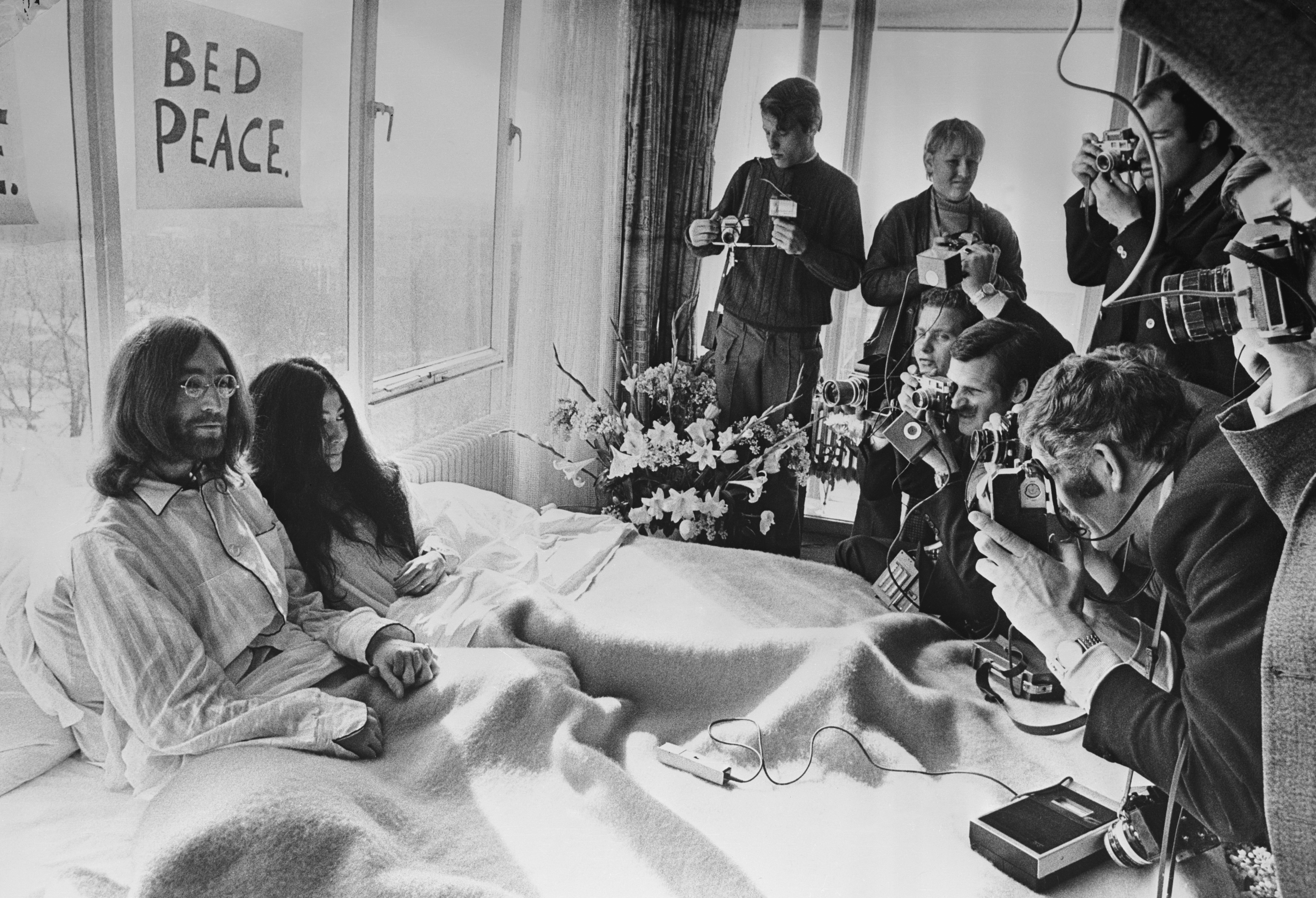 25 marzo 1969. John Lennon e Yoko Ono ricevono la stampa sul letto della loro suite presso l'Hilton di Amsterdam. La coppia inaugurò così il "bed in", una forma di protesta non-violenta contro la guerra in Vietnam che sarebbe durata fino al 31 marzo 