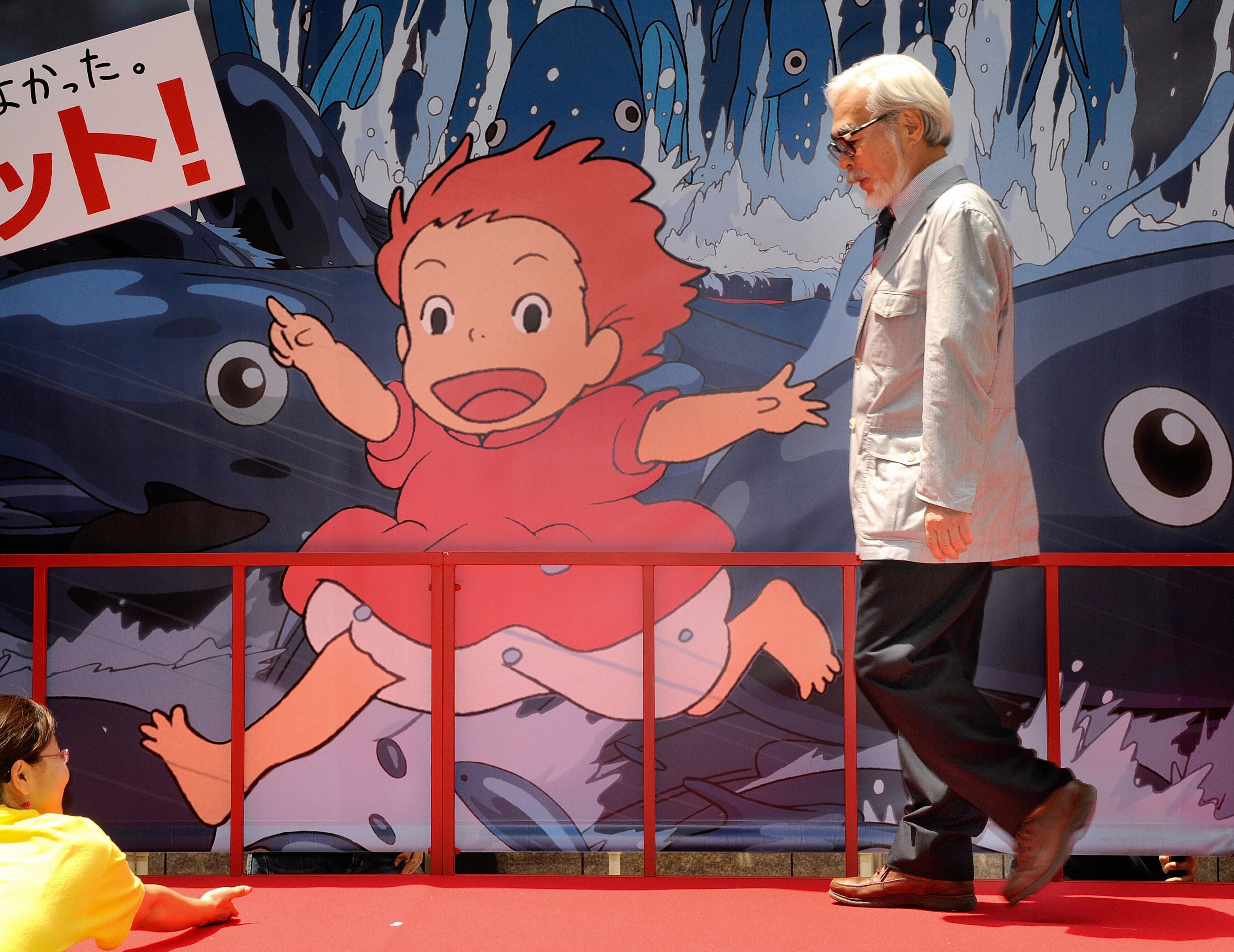 Miyazaki passeggia davanti al manifesto del film "Ponyo della scogliera" del 2008