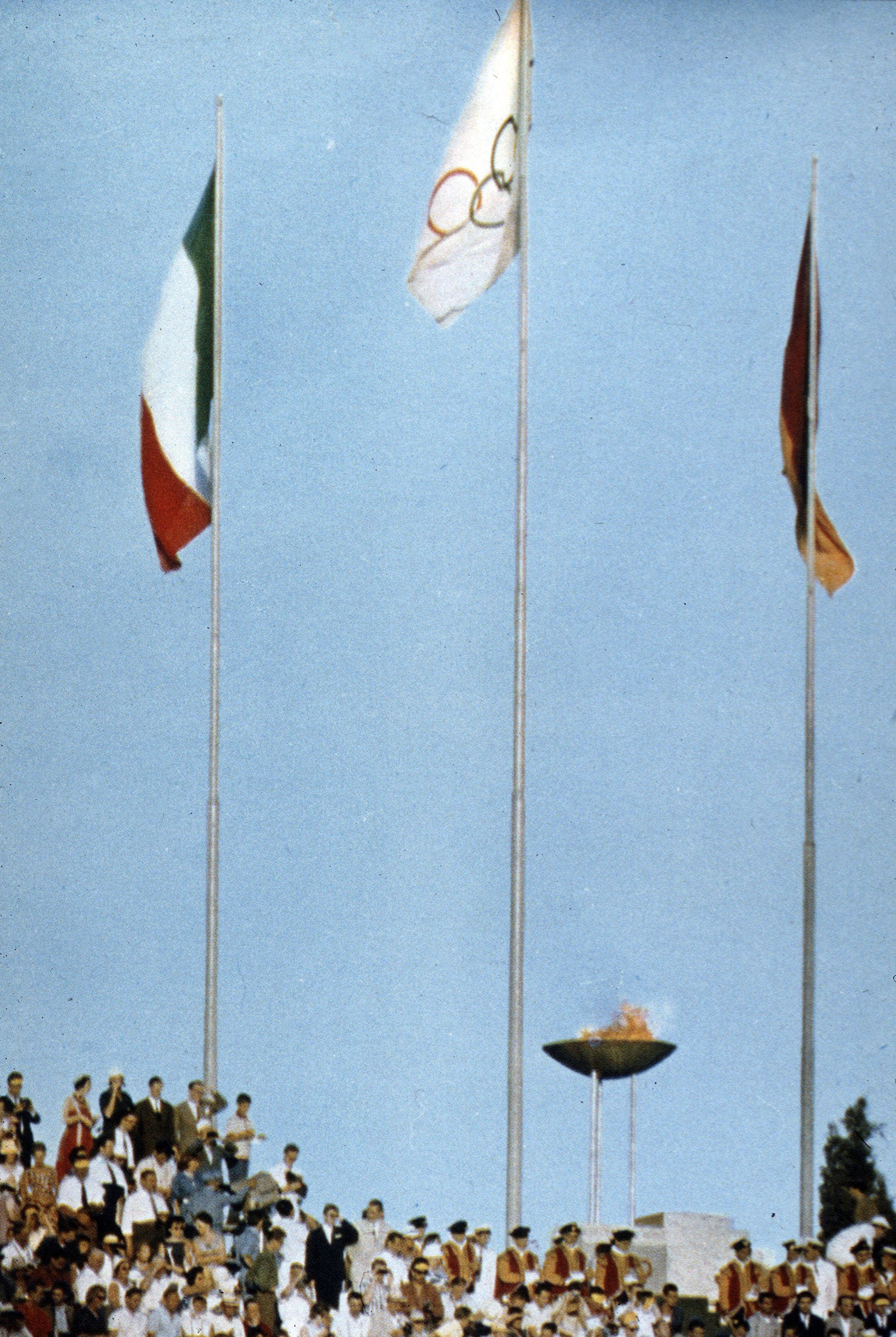 La fiaccola olimpica con il tricolore, la bandiera olimpica e quella della città capitolina
