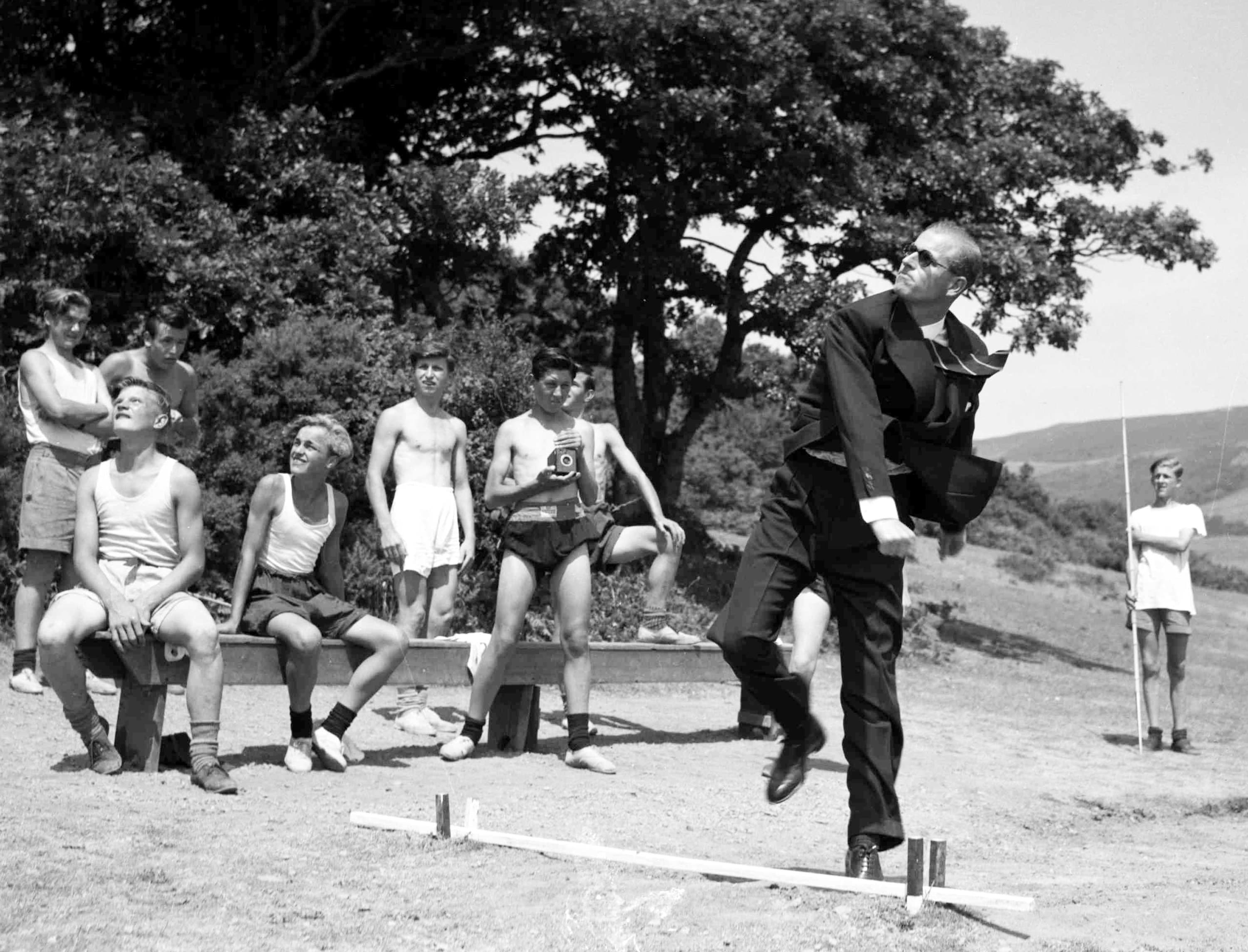 Nel 1949, Filippo lancia un giavellotto durante una visita alla Outward Bound Sea School, in Galles, osservata da alcuni dei ragazzi. Il Duca era molto appassionato di sport