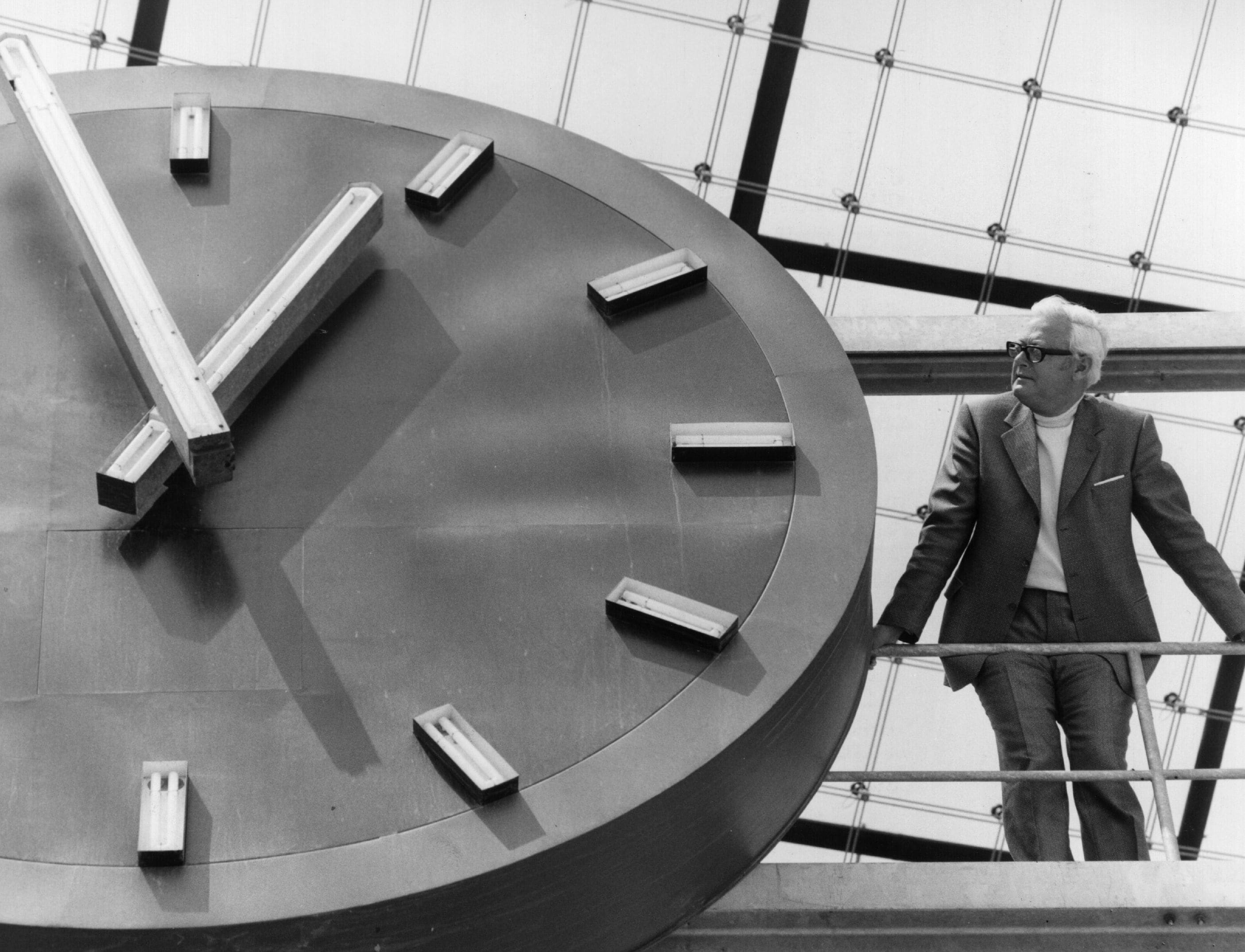 Il presidente della società edile olimpica per i giochi di Monaco , Carl Mertz, accanto all'orologio dello stadio