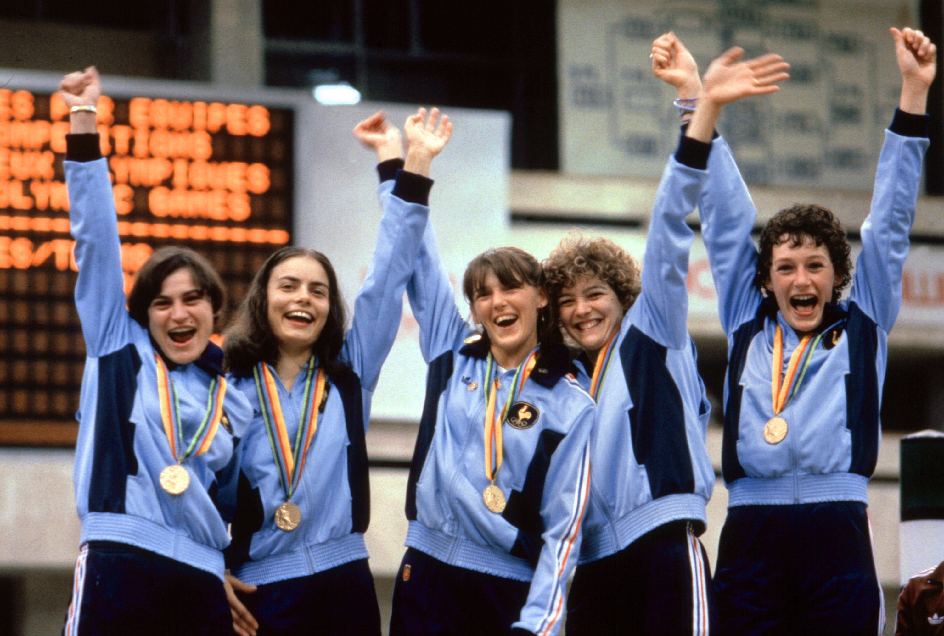 La squadra femminile francese di scherma sorride e alza le braccia sul podio dopo aver vinto l'oro