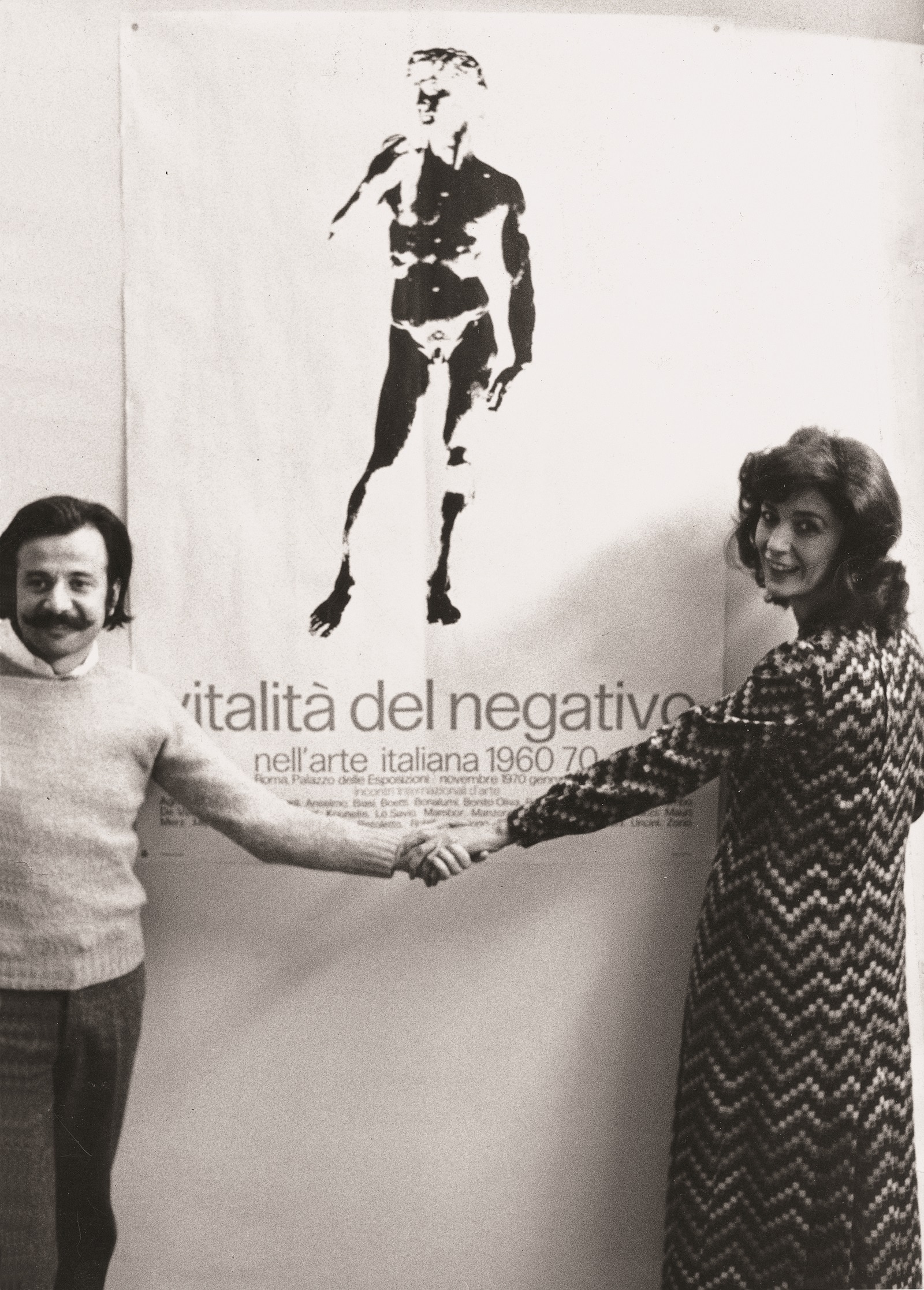 2. Vitalità del negativo, Achille Bonito Oliva e Graziella Lonardi Buontempo con il manifesto della mostra Vitalità del negativo nell’arte italiana 1960-1970, Palazzo delle Esposizioni, Roma, 1970 © Photo Massimo Piersanti, courtesy Archivio Massimo Piersanti