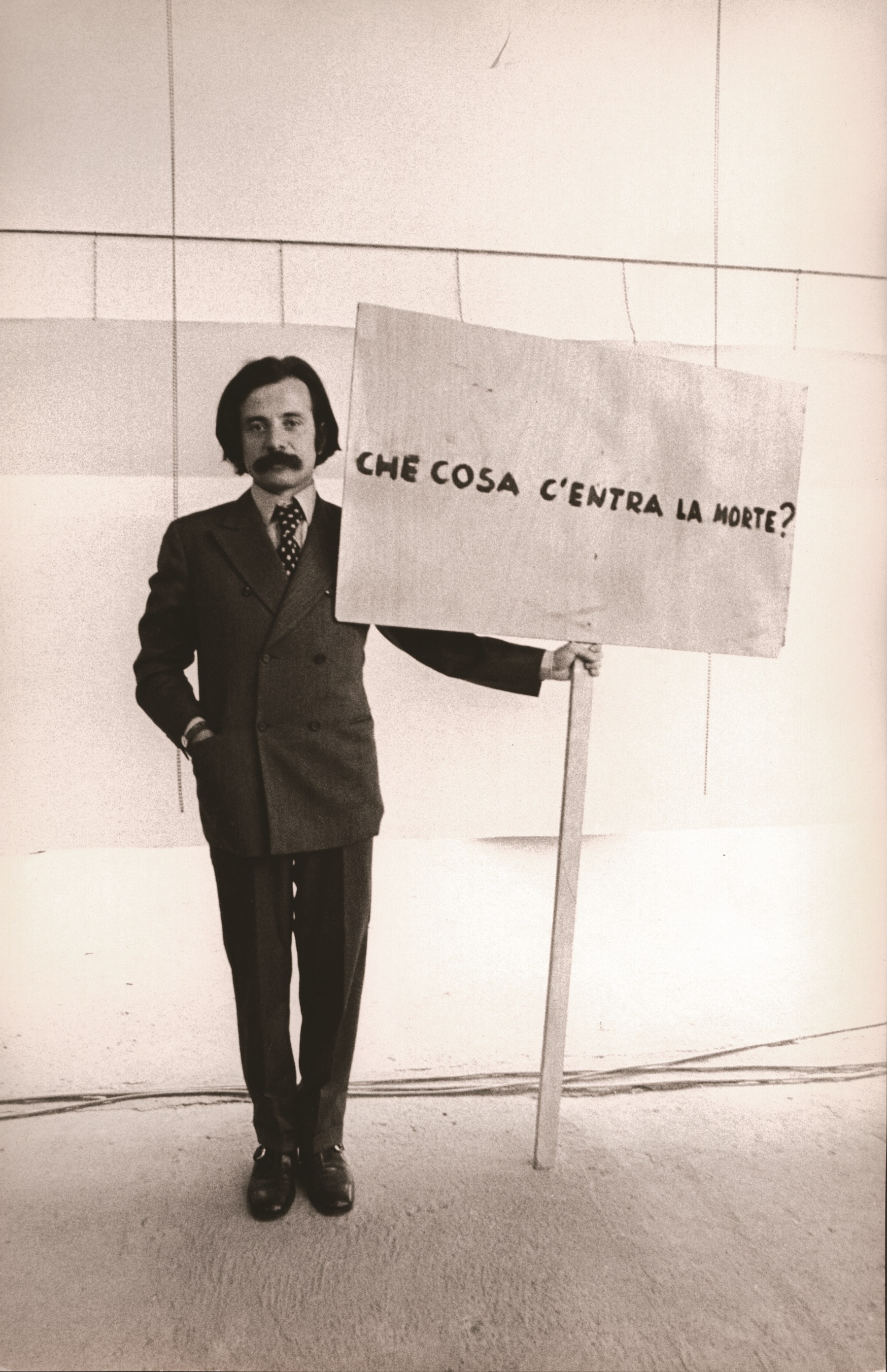 3. VII Biennale Parigi, Achille Bonito Oliva con il cartello di Gino De Dominicis, alla VII Biennale di Parigi, Manifestation Biennale et internationale des jeunes artistes, Parc Floral, Bois de Vincennes, Parigi, 24 settembre - 1 novembre 1971 © Photo Archivio Massimo Piersanti