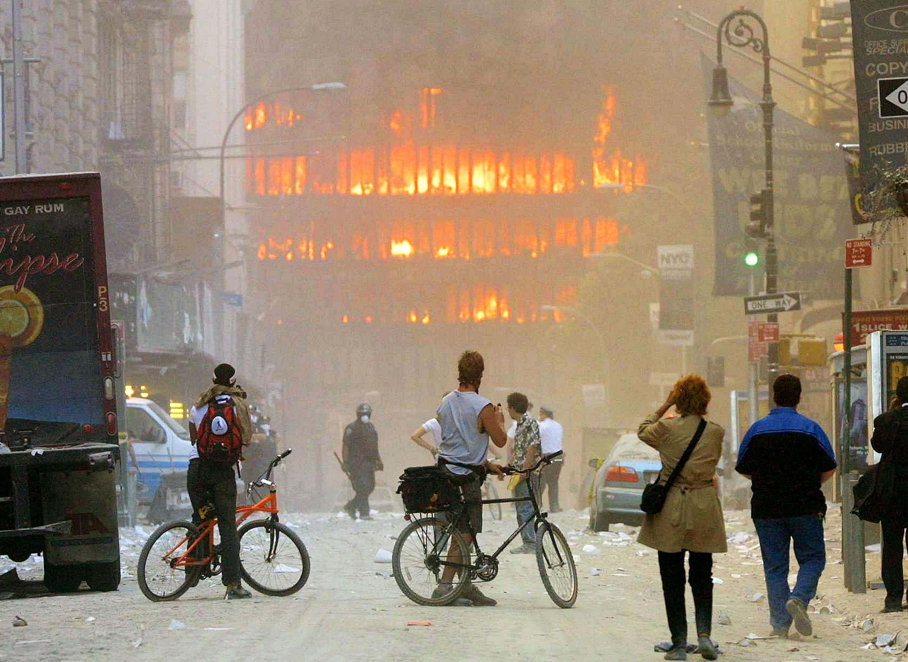 La gente assiste per strada agli edifici del World Trade Center che bruciano