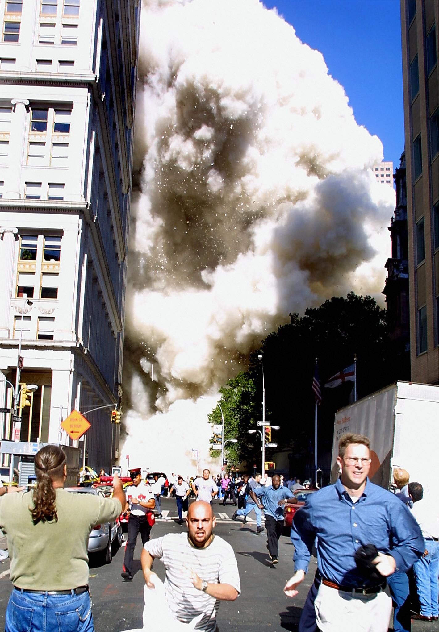 Pedoni che scappano dalla scena del crollo di una delle torri del World Trade Center. Gli attentati si svolgono praticamente in diretta televisiva, con milioni di persone in tutto il mondo che seguono questi drammatici momenti sui vari mezzi di comunicazione