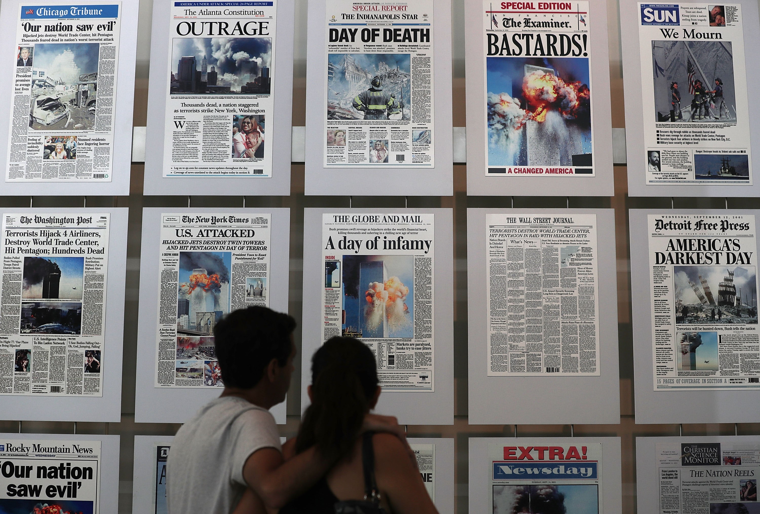 I visitatori sfogliano le prime pagine dei giornali con la storia degli attacchi terroristici presso la Galleria dell'11 settembre in occasione dell'anniversario del 2016