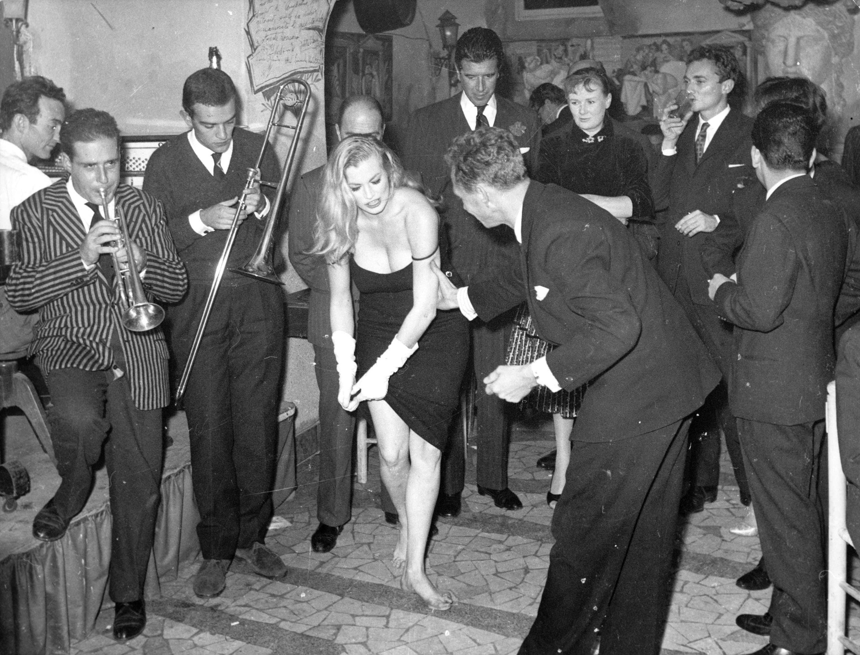 Scandalo al "Rugantino" di Roma: Anita Ekberg improvvisa uno spogliarello circondata dai paparazzi. E' il 5 novembre 1958