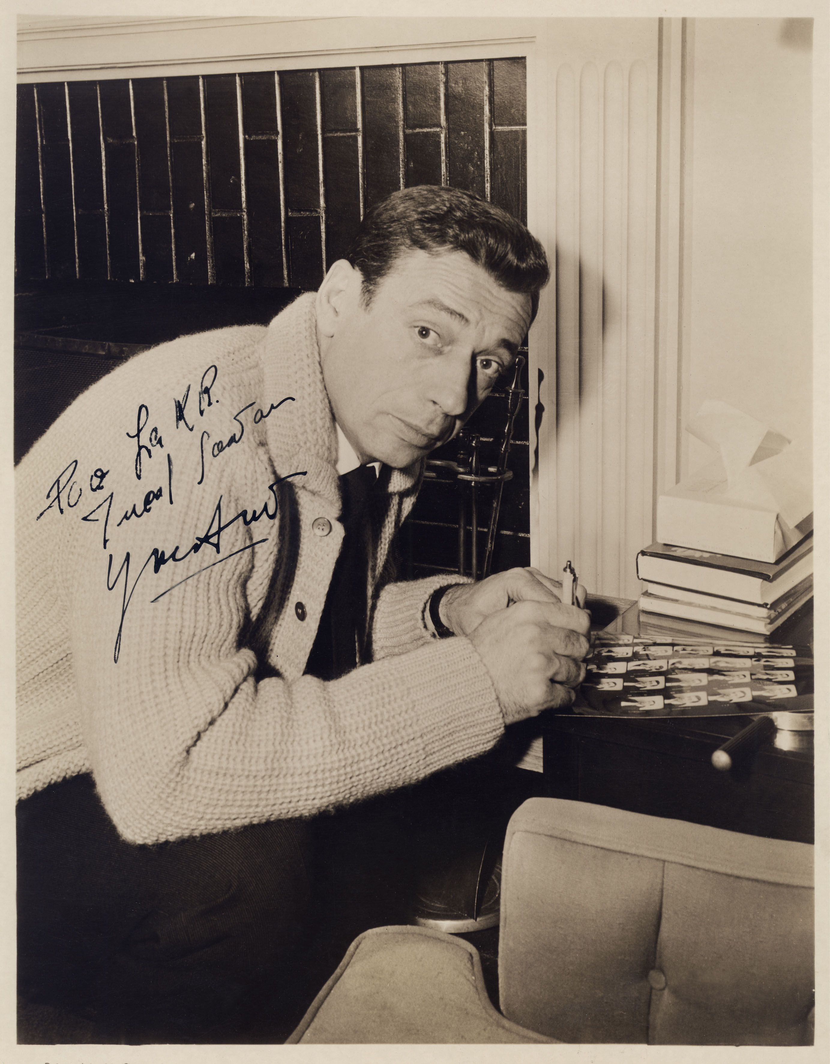 Yves Montand immortalato nel 1960 mentre firma autografi, popolarissimo per aver interpretato "Facciamo l'amore" al fianco della star Marilyn Monroe