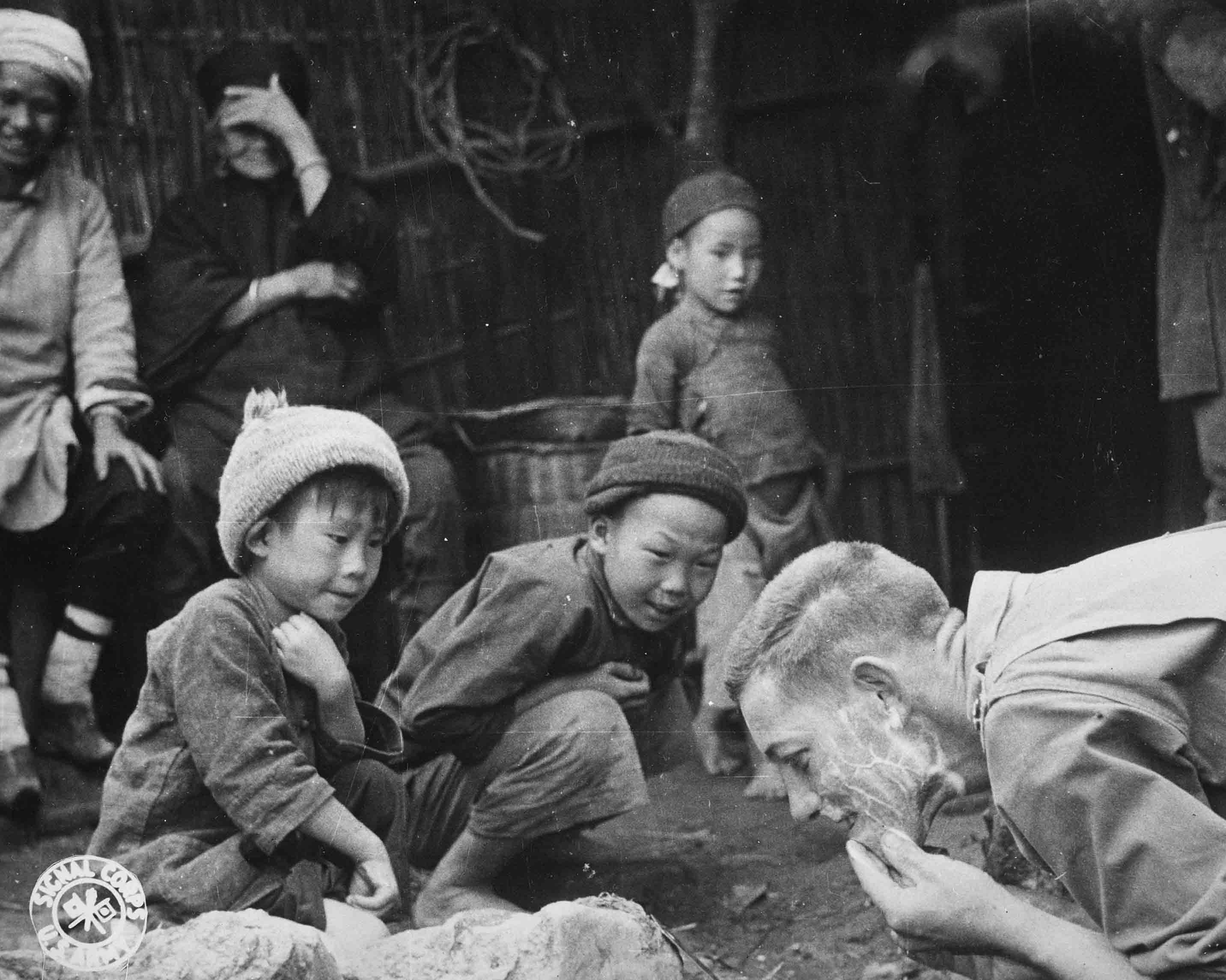 Questi due bambini cinesi sono affascinati dalla vista di un soldato americano che si rade all'aperto © courtesy U.S. National Archives and Records Administration / Collection National Archives at College Park