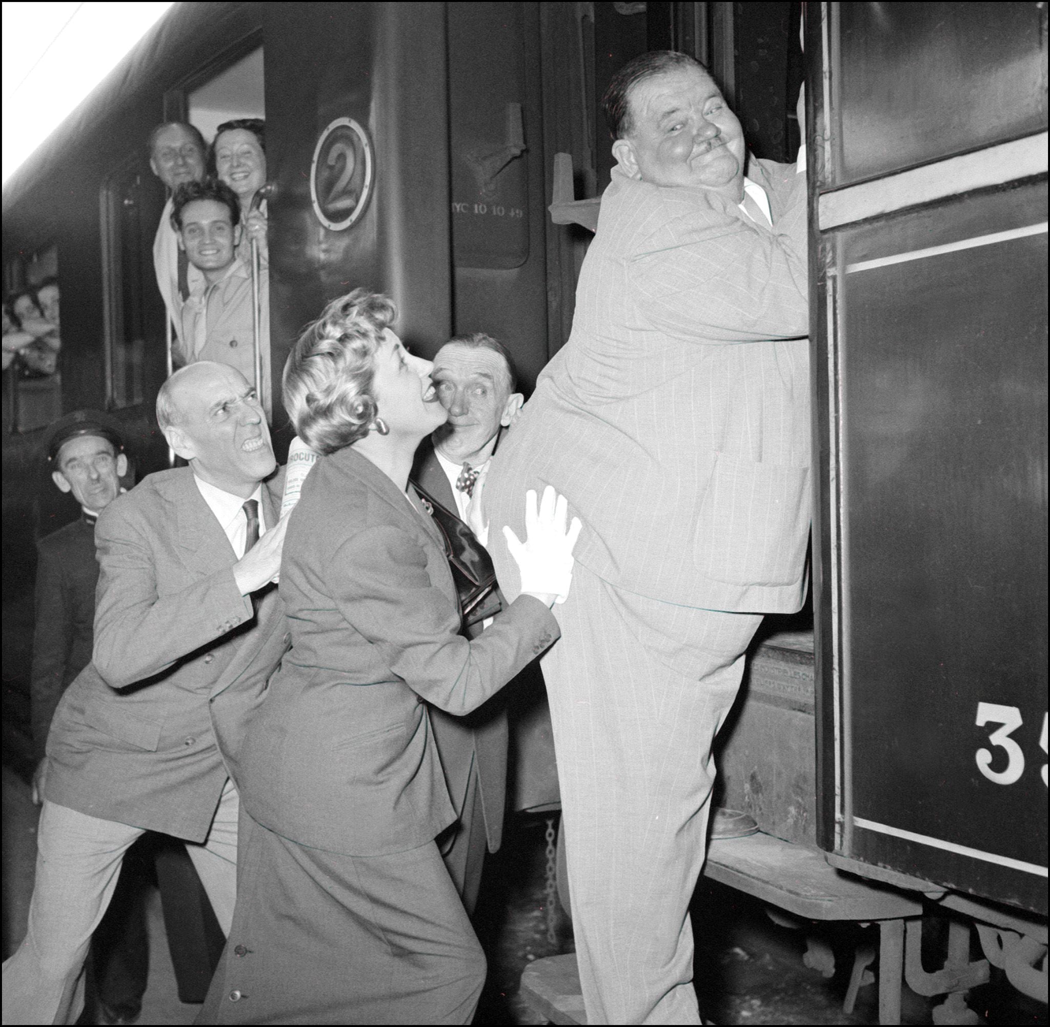 Parigi, stazione di Saint-Lazare: l'attrice francese Suzy Dalair spinge Oliver Hardy sul vagone del treno nel 1951