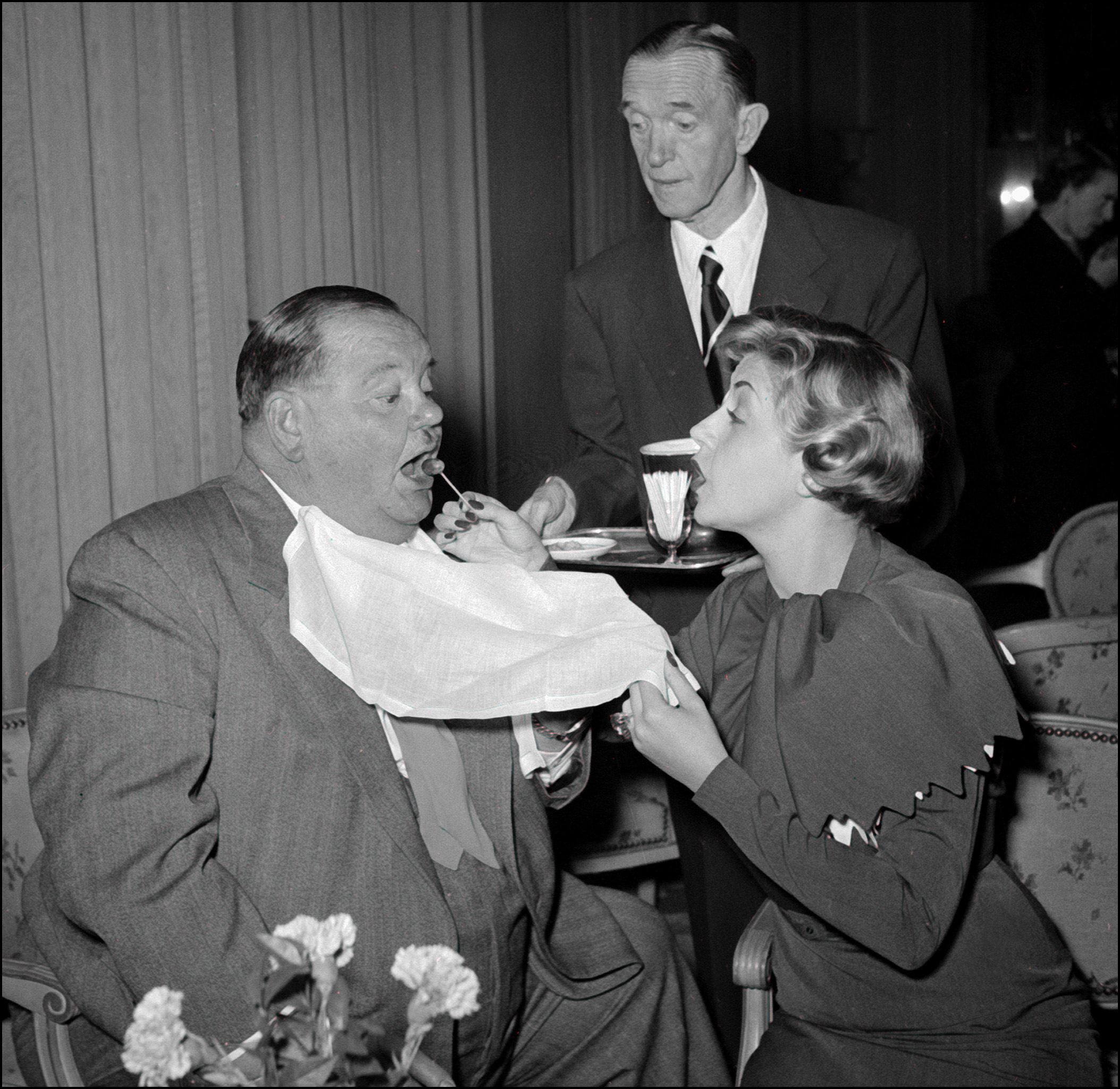 Oliver Hardy si fa imboccare dall'attrice francese Suzy Delair nel 1951