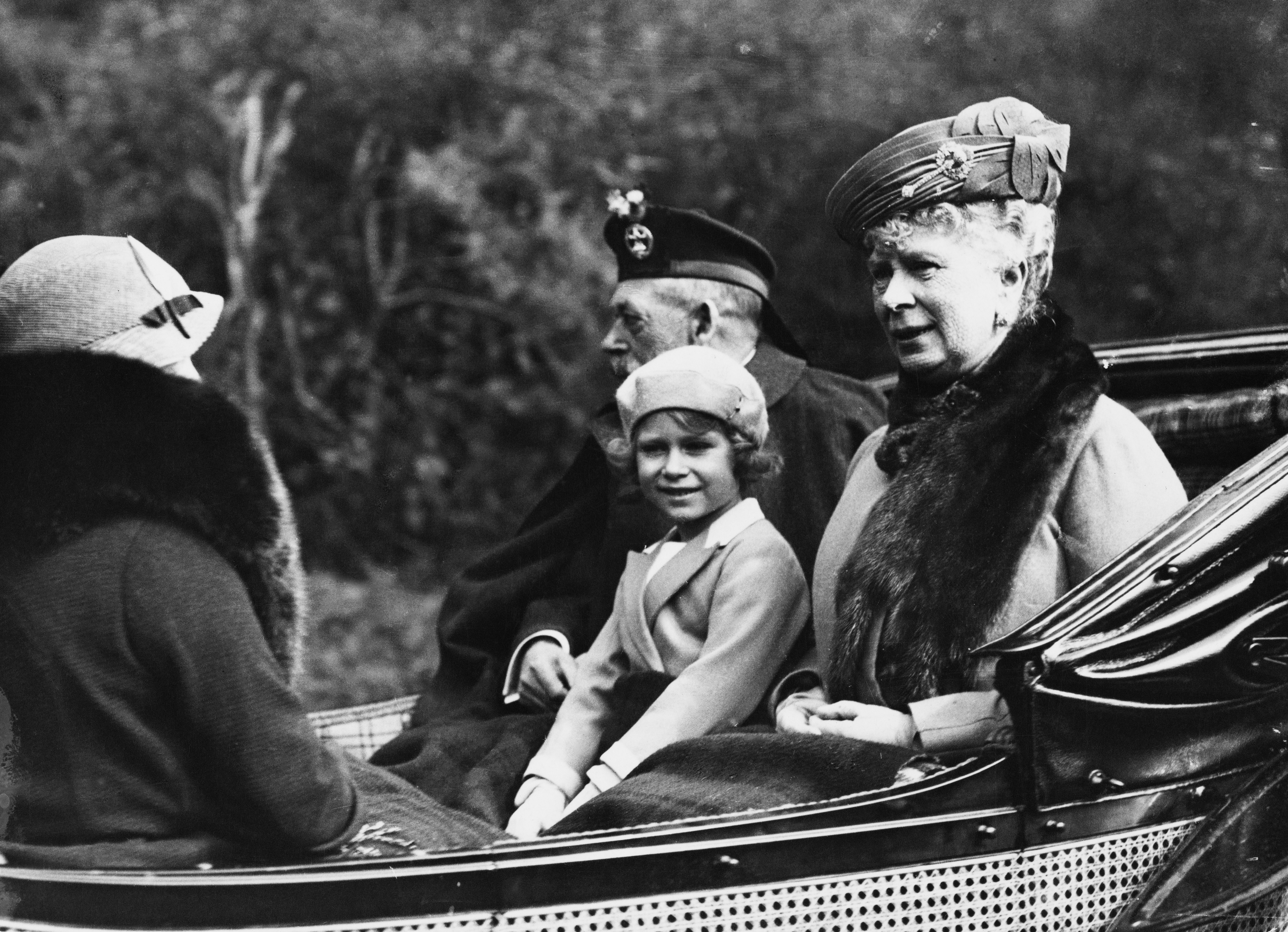 La principessa Elisabetta (poi regina Elisabetta II) seduta tra suo nonno re Giorgio V (1865-1936) e la nonna regina Mary di Teck (1867-1953) mentre tornano in carrozza al castello di Balmoral da Crathie Kirk vicino a Braemar in Scozia in agosto 1935