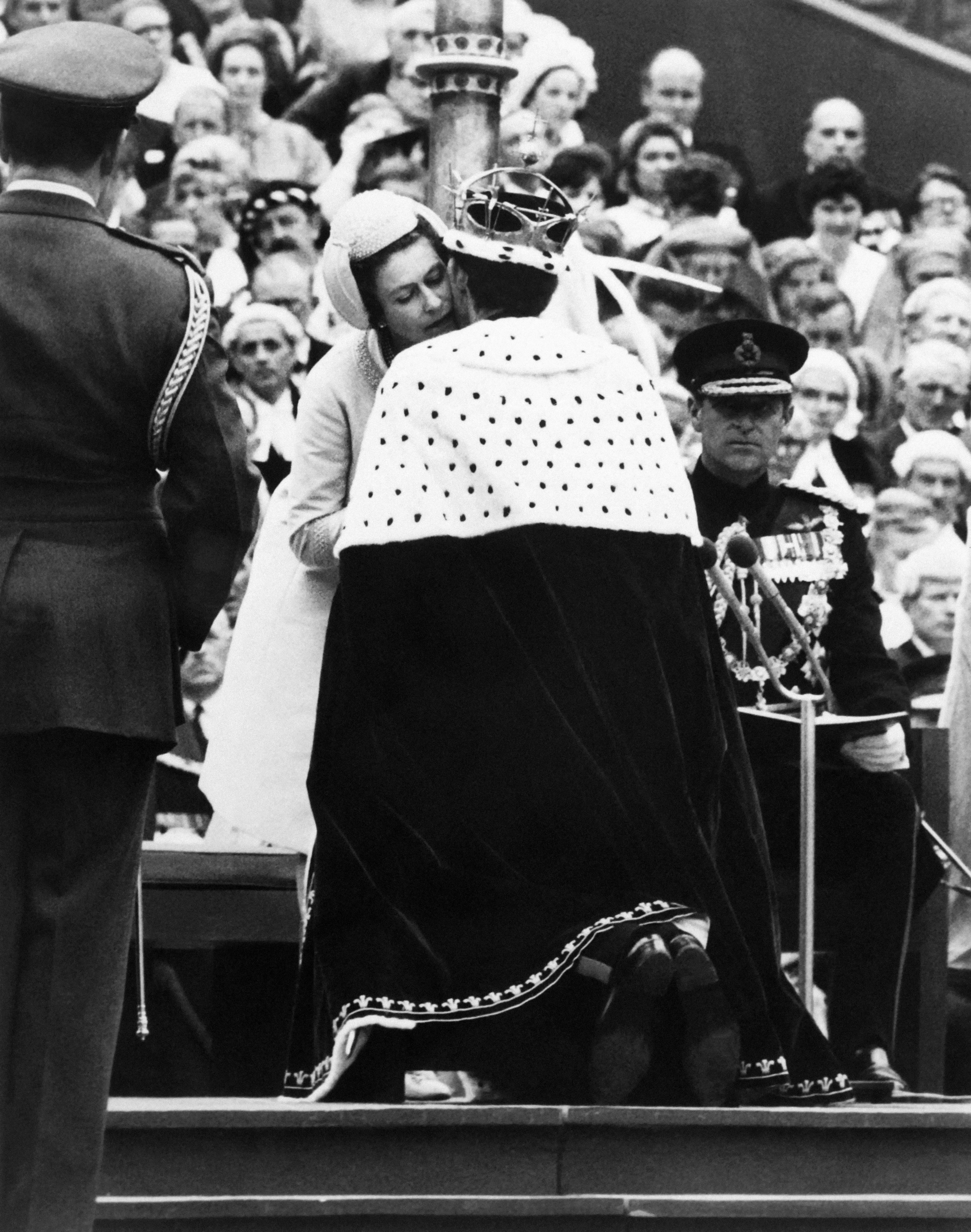 Il principe Carlo bacia sua madre, la regina Elisabetta II, durante la sua investitura come nuovo principe di Galles a Caernarfon il 1 luglio 1969