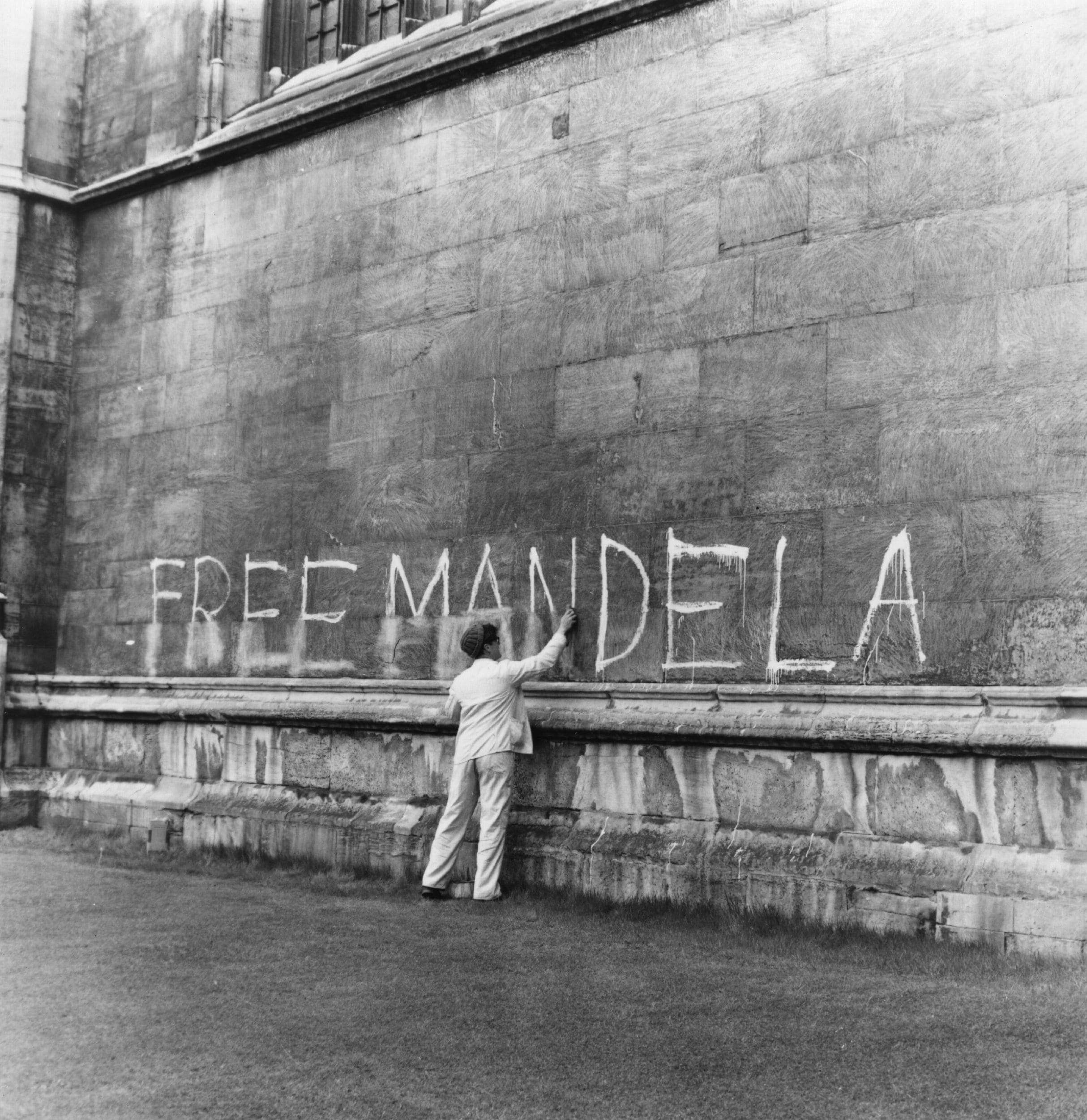 Un uomo lava uno slogan "Free Mandela" fuori dal lato della Cappella del King's College di Cambridge. 