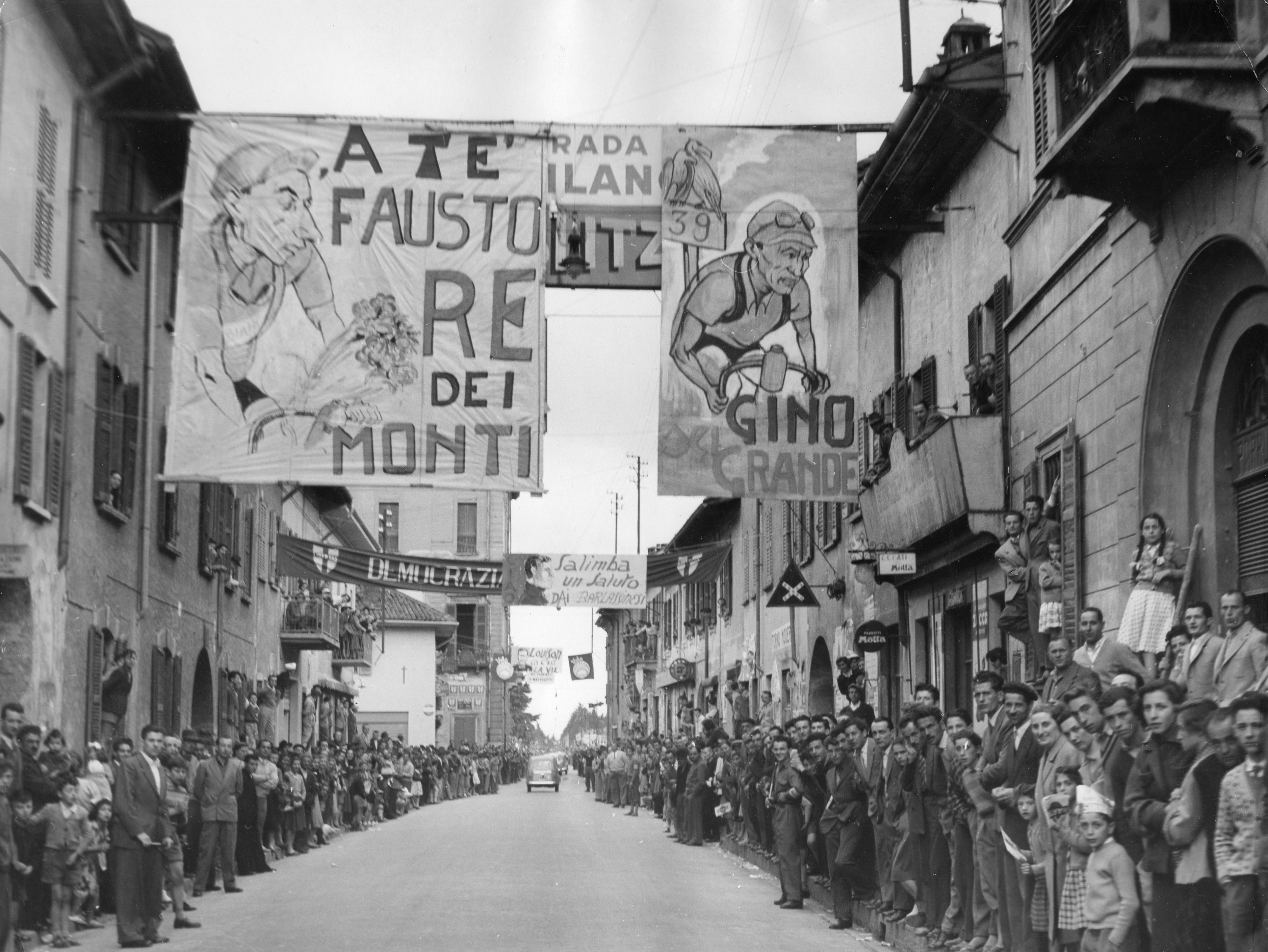 Giro d'Italia 1953: a Bormio tra gli striscioni elettorali spiccano cartelli di incitamento per Gino Bartali e Fausto Coppi, protagonisti della corsa ciclistica