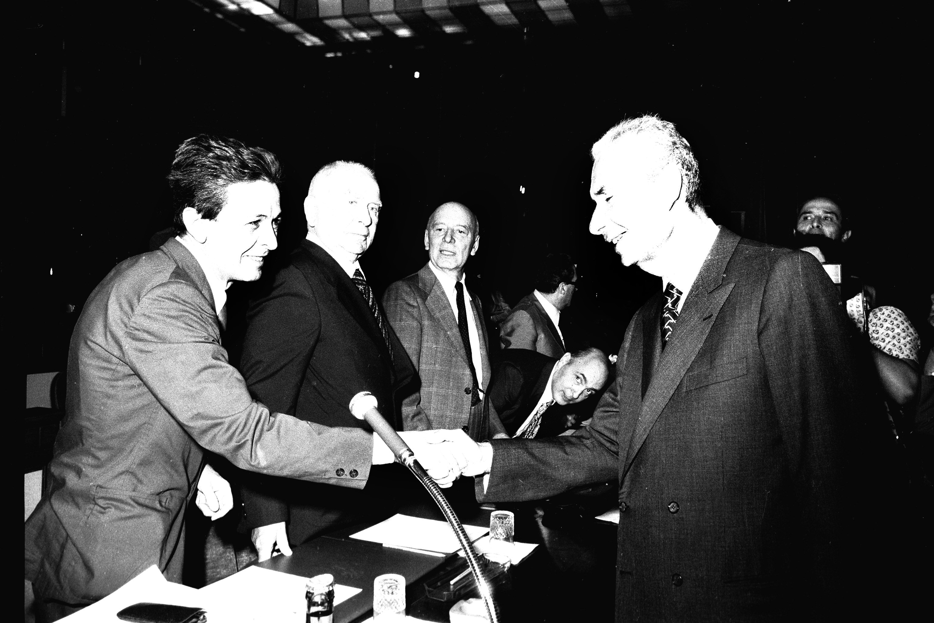 28 giugno 1977: una stretta di mano tra il segretario del Partito Comunista Italiano Enrico Berlinguer e il presidente della Democrazia Cristiana Aldo Moro, che simboleggia la politica di riavvicinamento e collaborazione ispirata da Berlinguer per trovare un accordo fra le forze popolari di ispirazione comunista e socialista con quelle di ispirazione cattolico-democratica