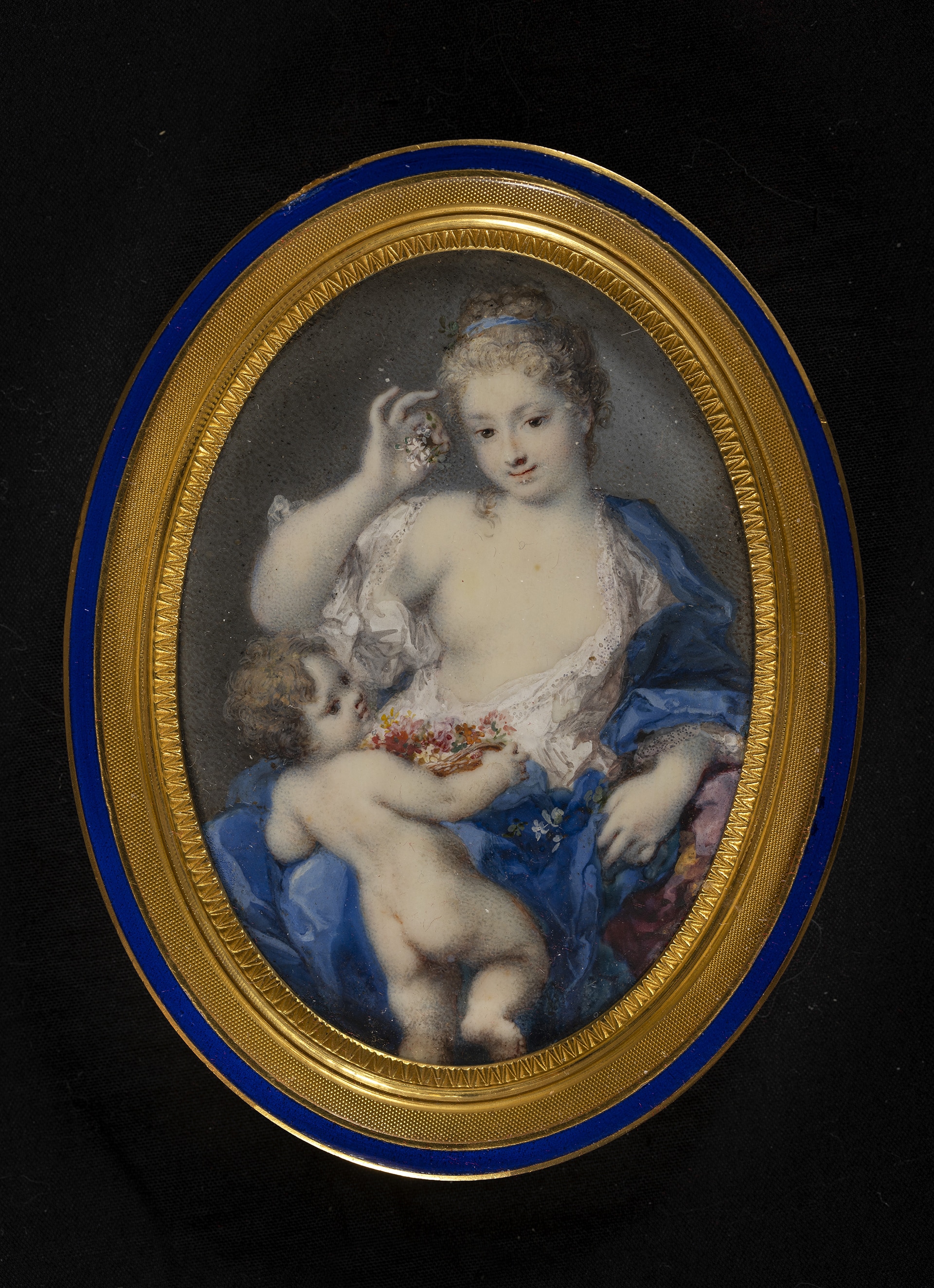 Rosalba Carriera, Flora con putto (Venere e Cupido), acquerello e gouache su avorio, cm 8 x 5,7 (ovale), 1726 - 1728. Accanto ai ritratti, in mostra compaiono alcune miniature di soggetto mitologico caratterizzate da una spiccata idealizzazione delle figure che consente a Rosalba di raggiungere vertici assoluti di grazia e poesia. È il caso del bel quadretto con Venere e Amore nel quale colpisce l’incarnato bianchissimo della dea, la delicata posa delle braccia che cingono in un morbido ovale il piccolo Cupido.