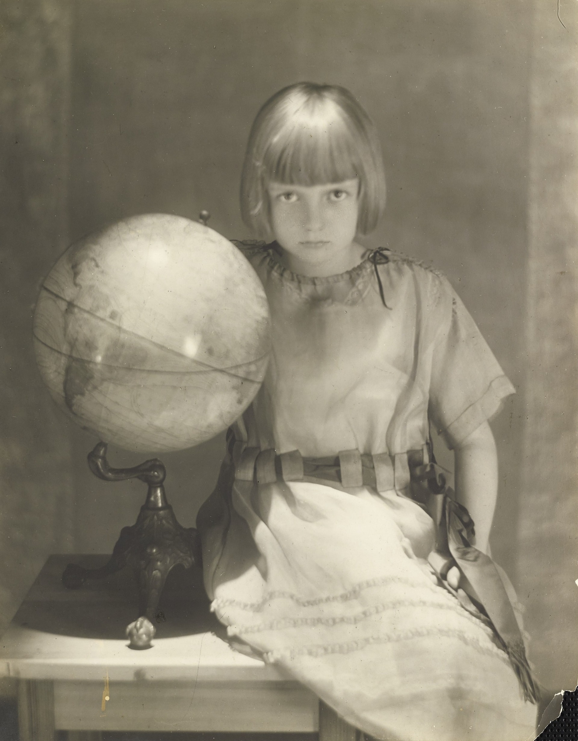 Adolf de Meyer, Bambina seduta accanto a un mappamondo, 1919, Vogue © Condé Nast