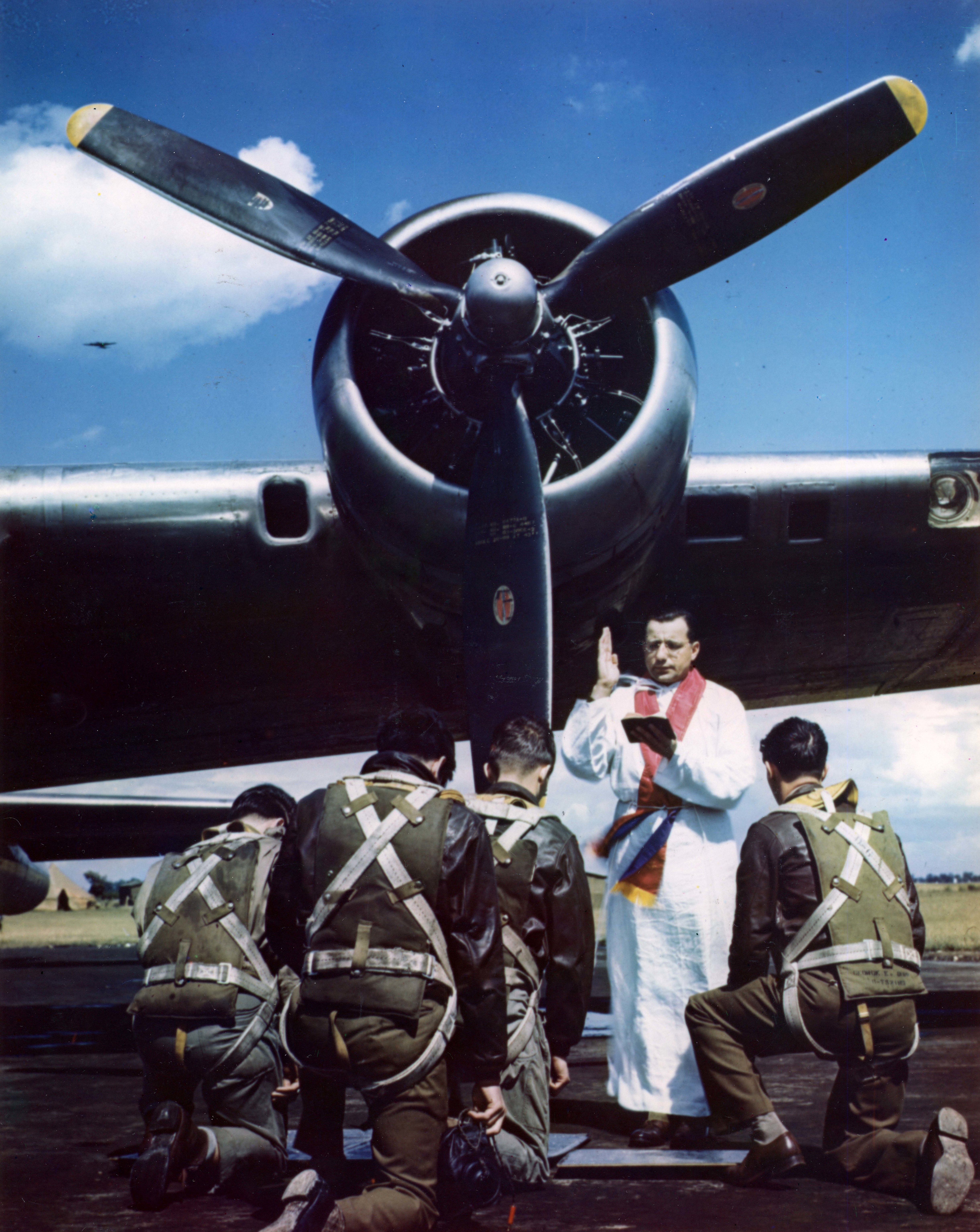 Un’orazione guidata dal Capitano M. S. Ragan, Padre Cattolico, in una base all’avanguardia di fortezze volanti in Inghilterra, prima che l'equipaggio parta per un attacco diurno all'Europa dominata dai nazisti. Il capitano Ragan era l'ex assistente del pastore della chiesa di St. Paul, Cleveland, Ohio. Inghilterra, 1944. Fotografo: sconosciuto o non fornito Per gentile concessione degli U.S. National Archives Digitalizzato da Signal Corps Archive. 
