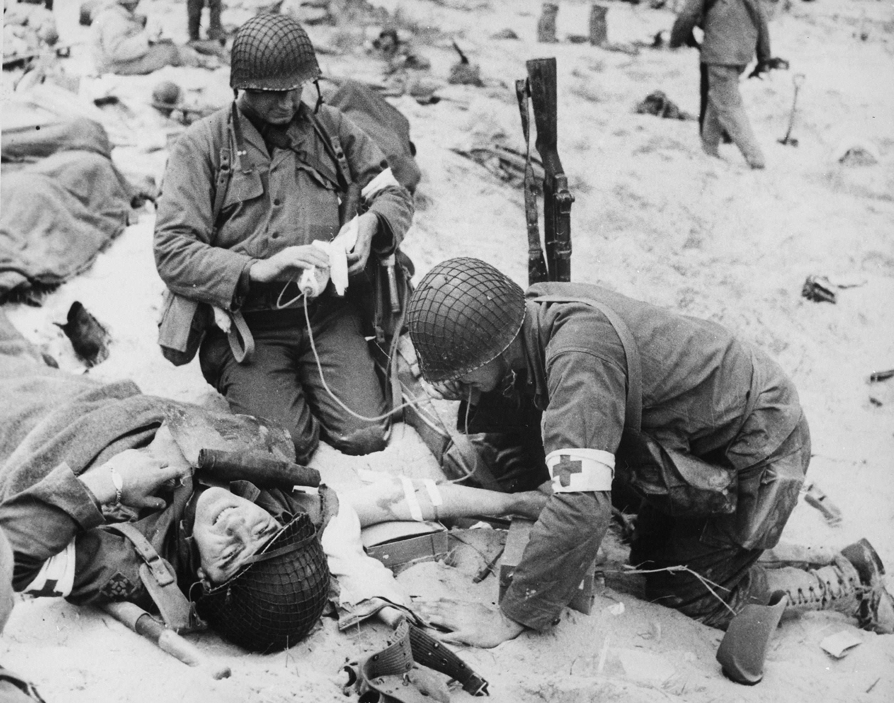 Medici soccorrono un soldato ferito. 6 giugno 1944. Spiaggia di Omaha, Normandia, Francia Fotografo: sconosciuto o non fornito Per gentile concessione degli U.S. National Archives 