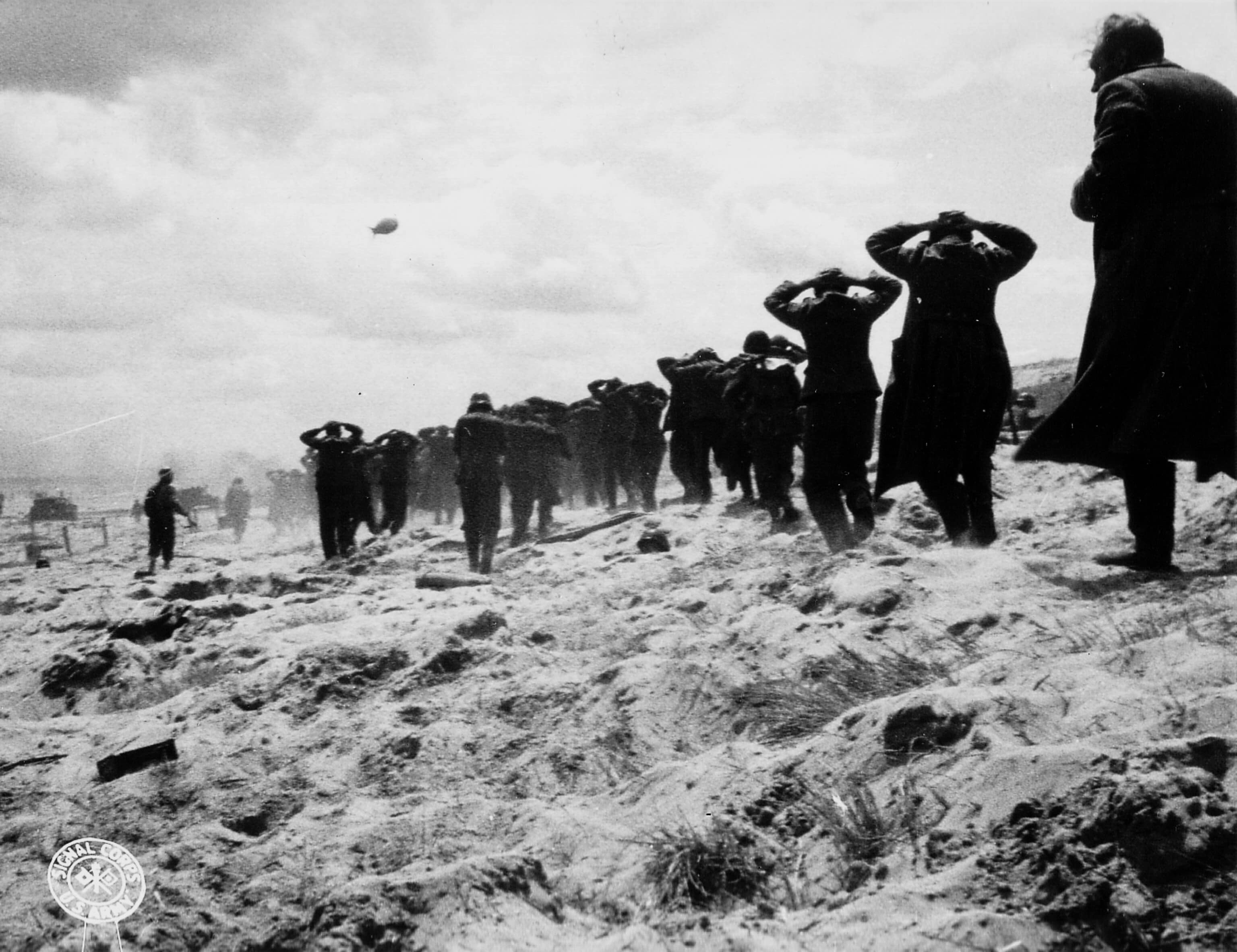 Una fila di prigionieri tedeschi avanza sulla duna di una spiaggia, settore Utah Beach, mani sulla testa, 6 giugno 1944 Utah Beach, Normandia, Francia. Fotografo: sconosciuto o non fornito Per gentile concessione di Photos Normandie / U.S. National Archives 