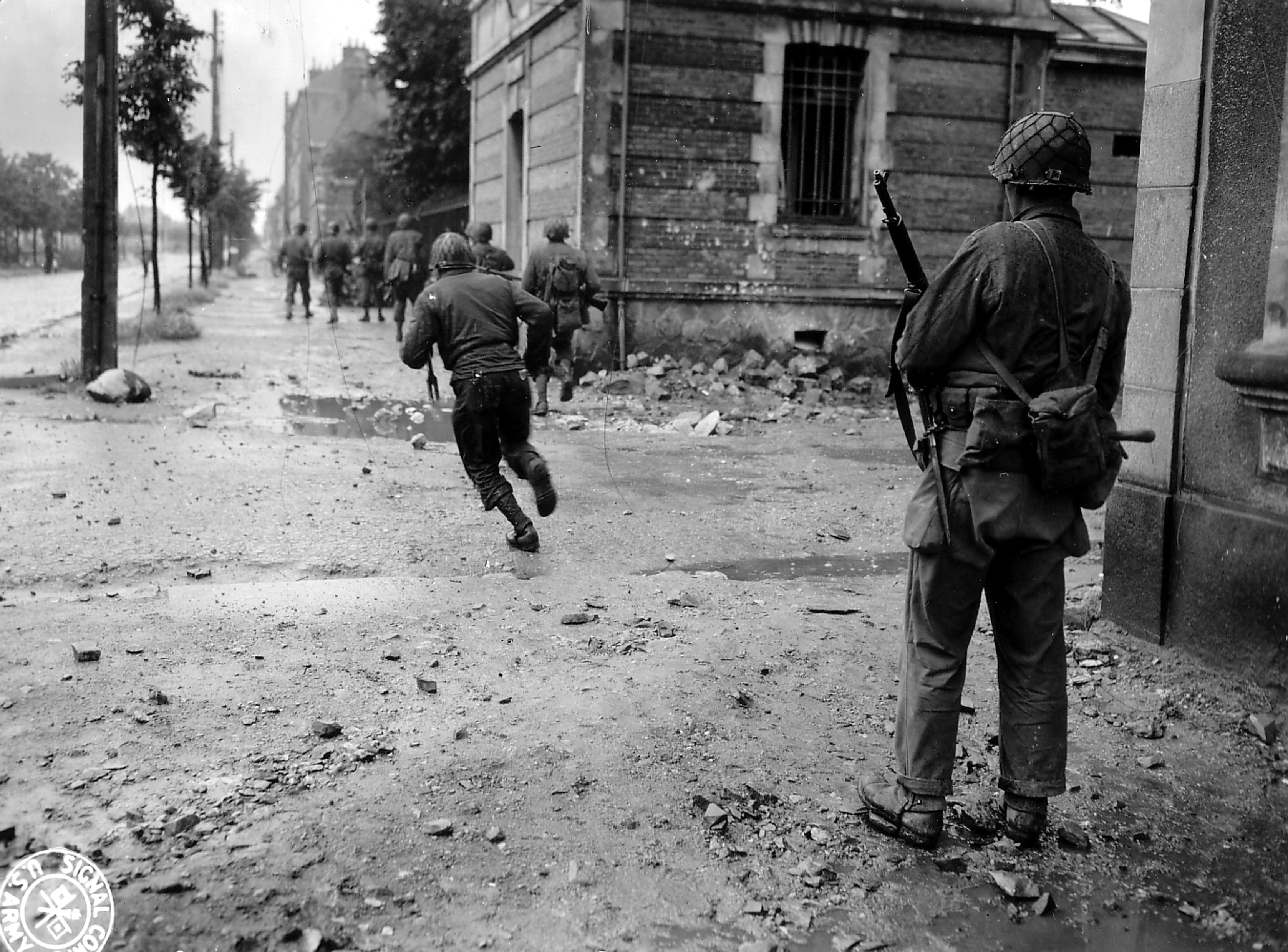Soldati americani in combattimento in una strada. Giugno 1944, Avenue de Paris, Cherbourg, Francia. Fotografia dell'US Army Signal Corps Per gentile concessione di Photos Normandie / U.S. National Archives 