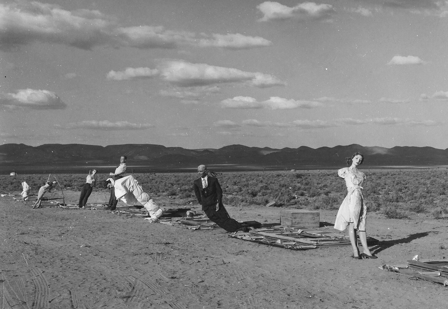 Operation Cue - Linea di manichini a 7.000 piedi (circa 2133 mt.) di distanza dal punto di impatto, durante un test per verificare l’effetto a posteriori delle radiazioni atomiche. Uno dei tanti esperimenti dell’operazione Cue finalizzati a misurare le conseguenze su abitazioni, oggetti ed essere umani di un’esplosione atomica. 5 maggio 1955, Yucca Flat, Nevada, U.S.A. Autore sconosciuto o non fornito © courtesy National Archives at College Park / U.S. National Archives and Records Administration 